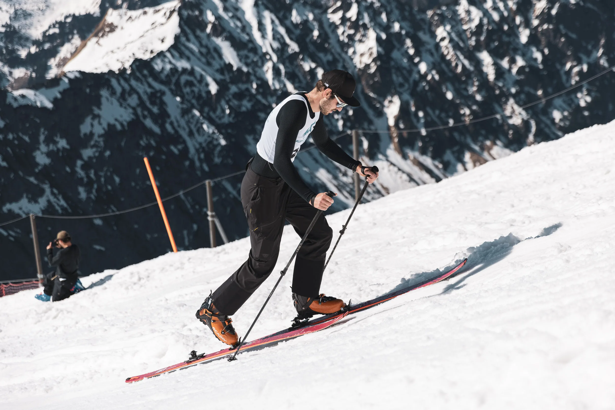 Skimo-Läufer steigt über einen sonnigen Firngrat auf, langer Schatten, Allgäuer Gipfel im Hintergrund