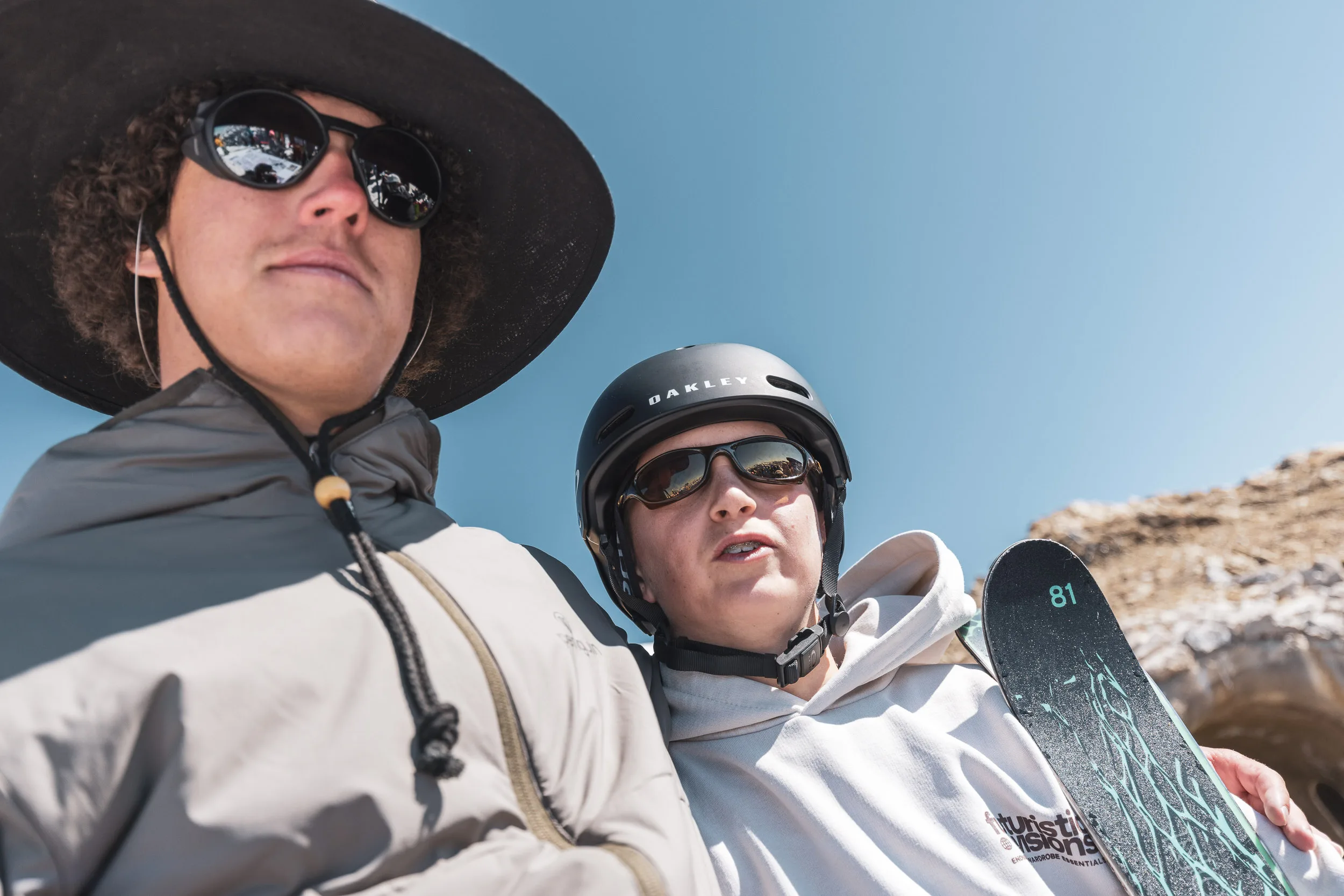 Zwei Teilnehmer in der Frühlingssonne am Berg, einer mit Hut, einer mit Helm und verspiegelter Brille