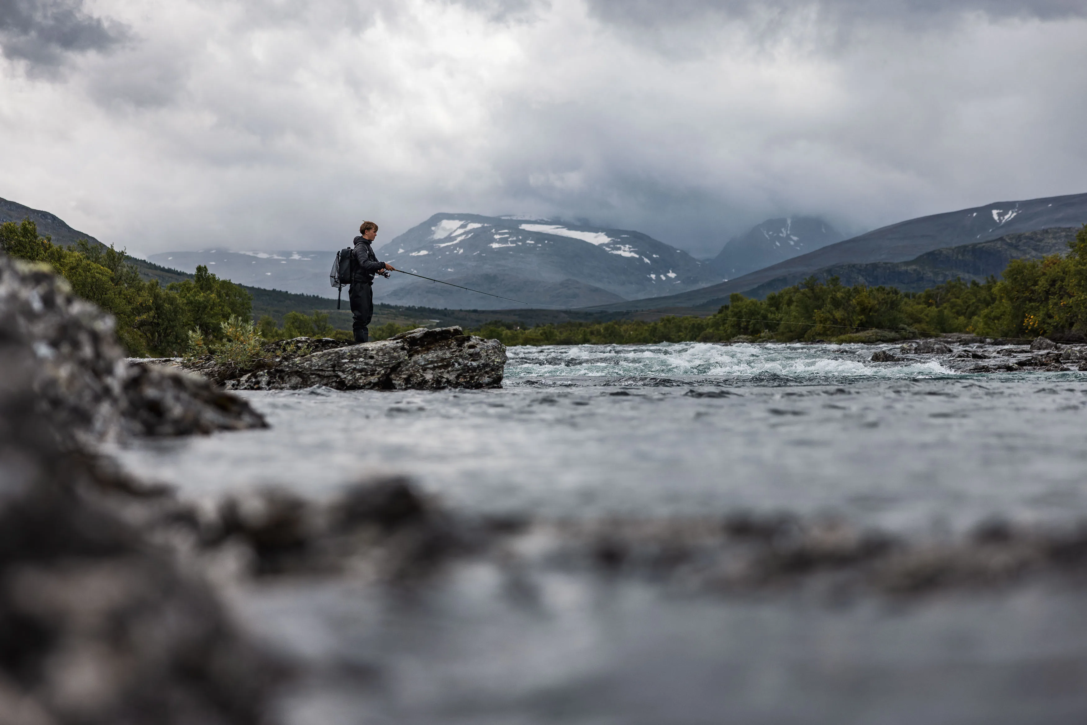 Kilian angelt von einem Felsen in einem norwegischen Gebirgsfluss