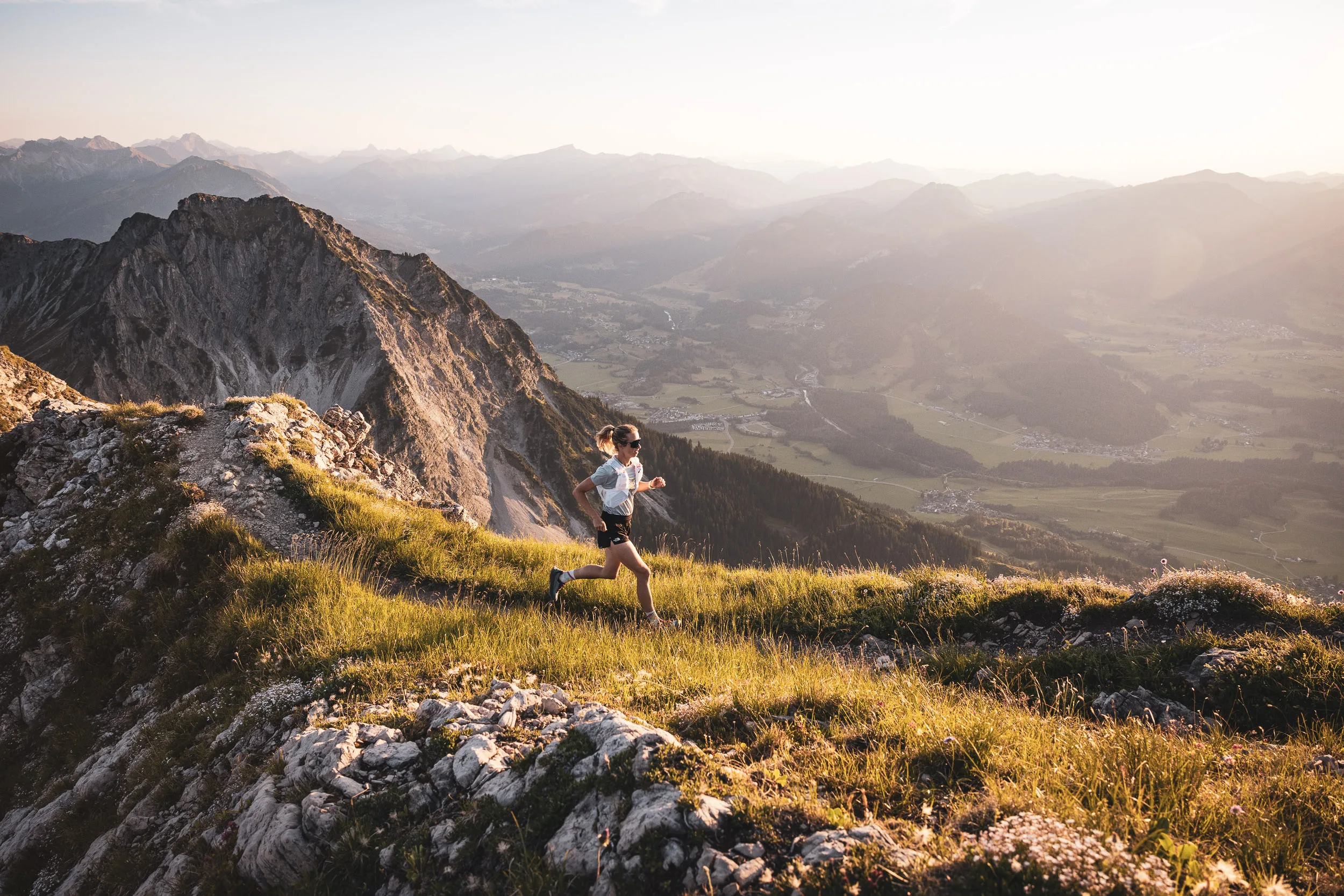 Ronja Morell läuft über einen sonnigen Grashang mit Blick ins Oberstdorfer Tal