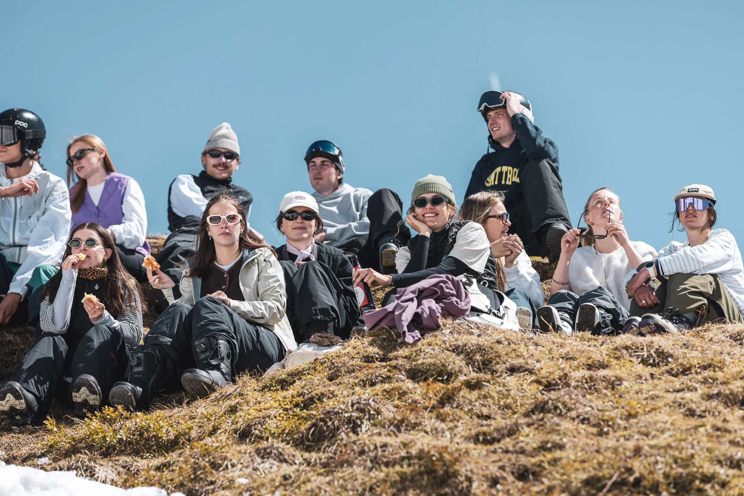 Publikum sitzt dicht gedrängt auf dem sonnigen Grasgrat und verfolgt die Läufe am Nebelhorn