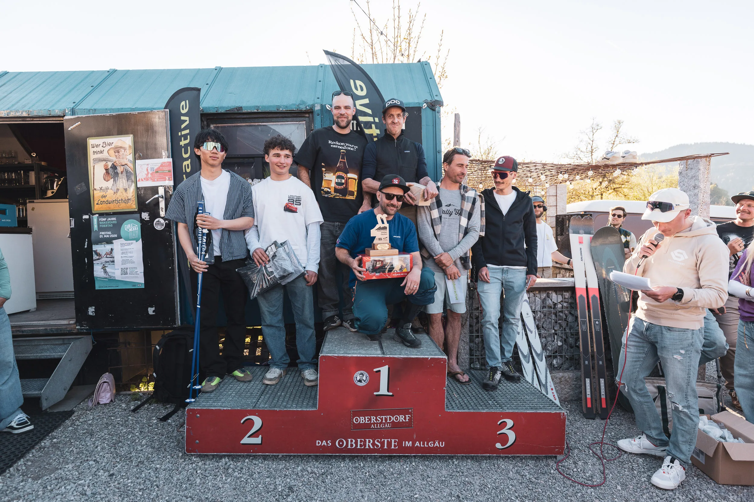 Siegerinnen und Sieger feiern auf dem Podest der Nebelhorn Spring Trophy vor der Après-Bar