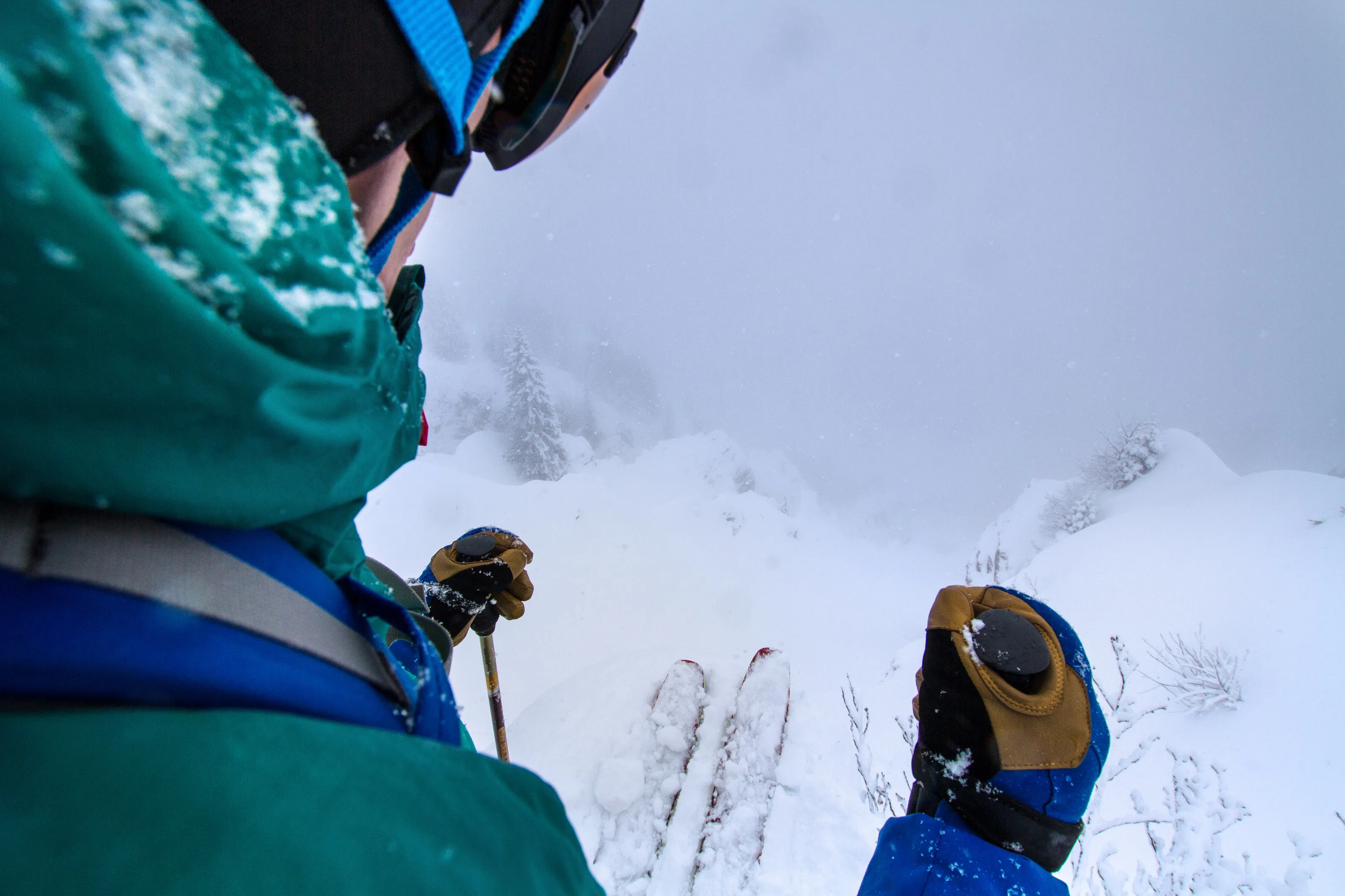 Blick über Skispitzen auf einen verschneiten Hang während eines Winteraufstiegs