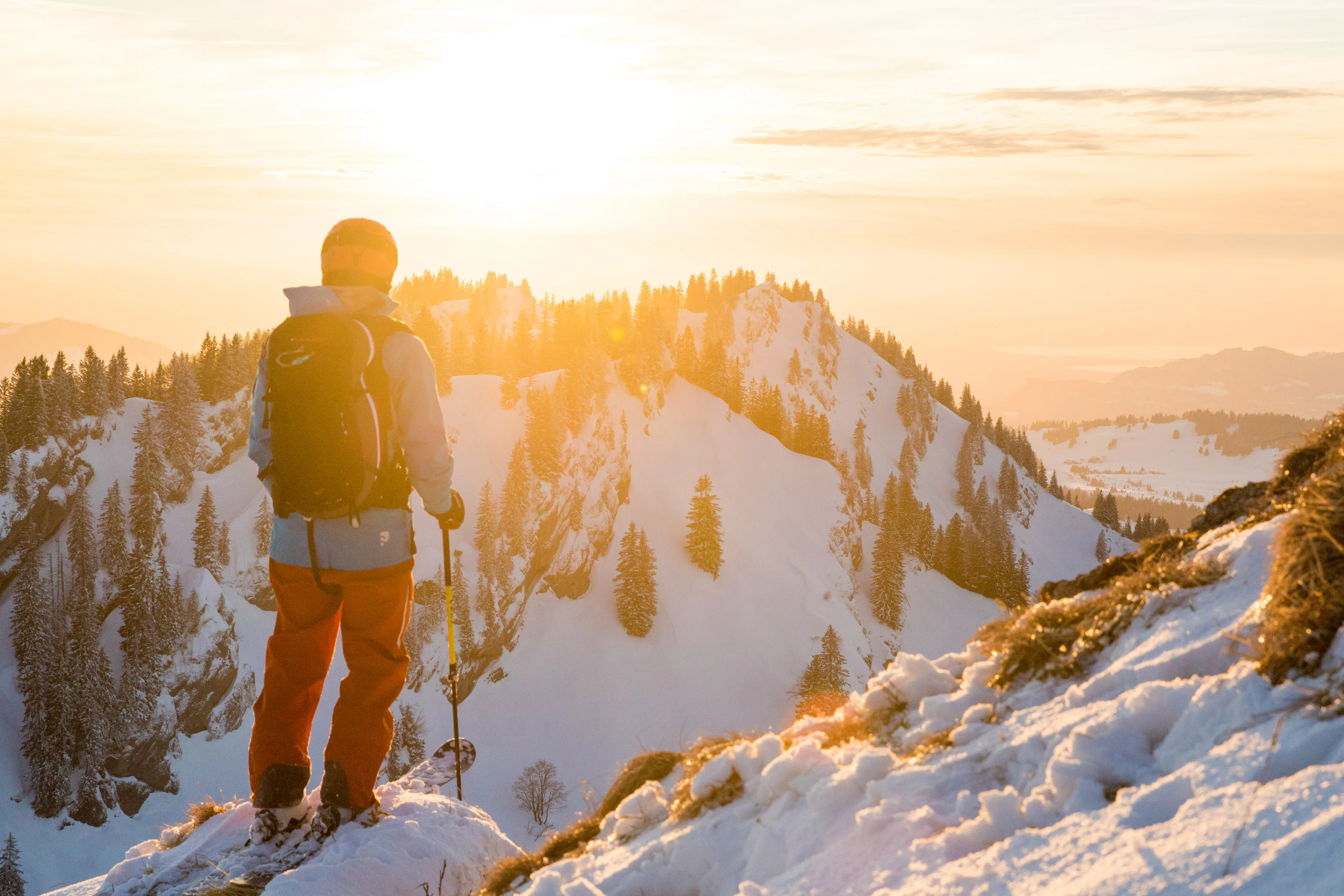 Florian Häusler mit Ski und Stöcken vor der tief stehenden Sonne am Hochgrat.