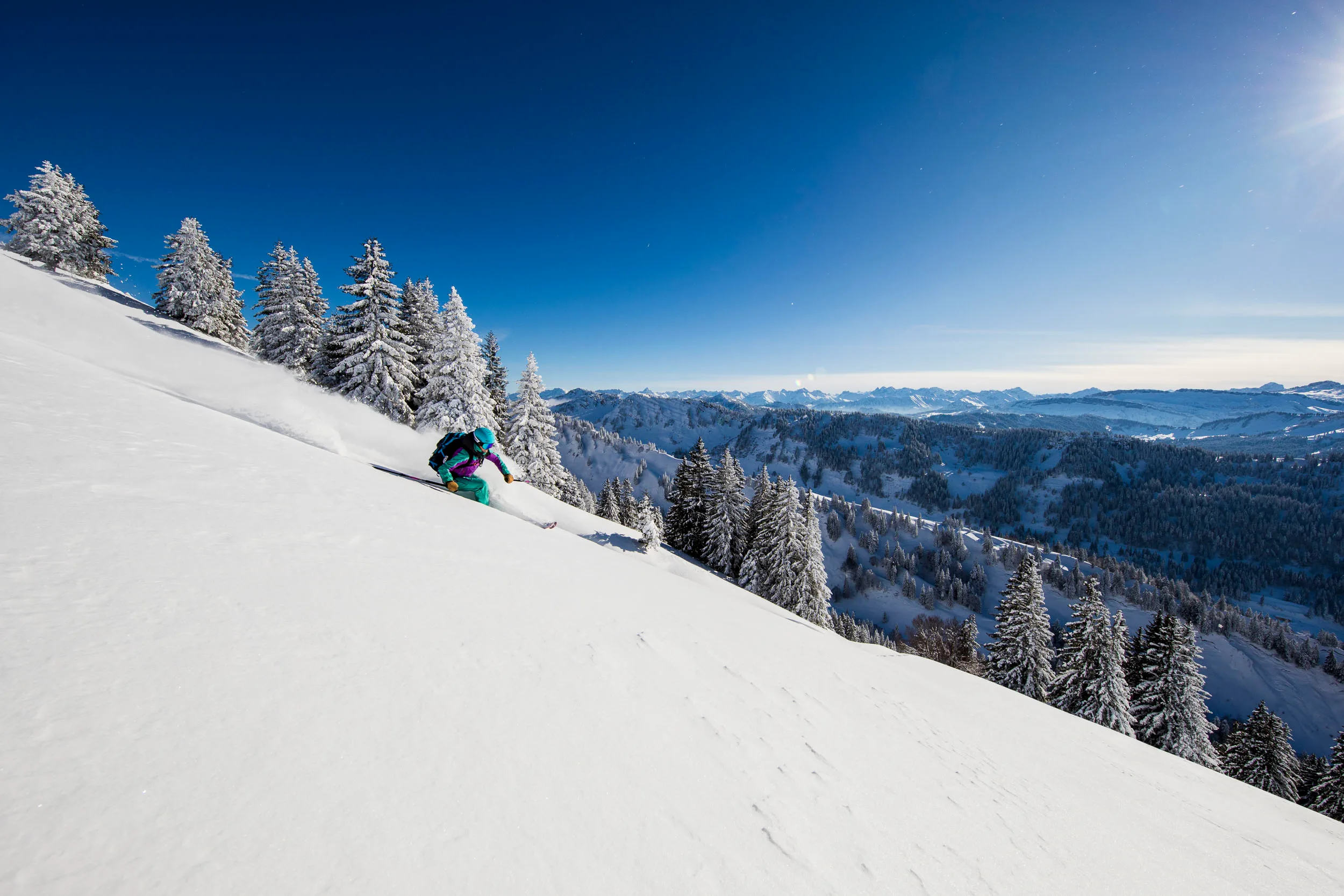 Skifahrerin fährt durch unberührten Schnee vor der Nagelfluhkette.