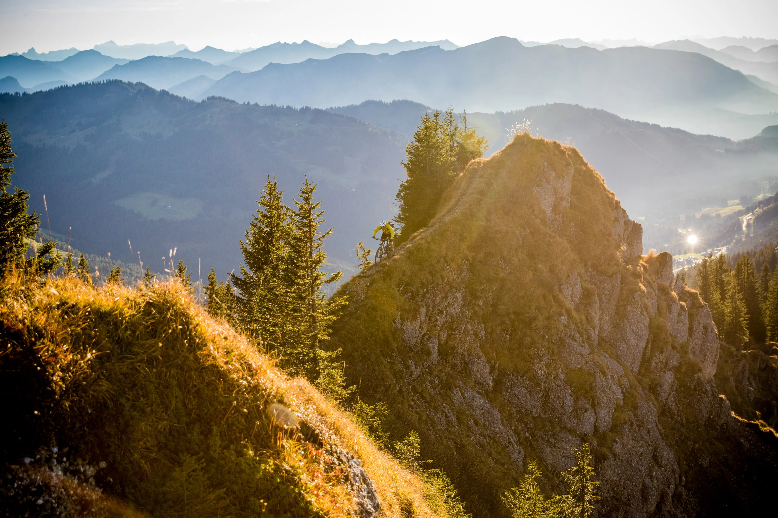 Florian Häusler fährt mit dem Mountainbike auf einem felsigen Gratweg vor dem Allgäuer Bergpanorama.