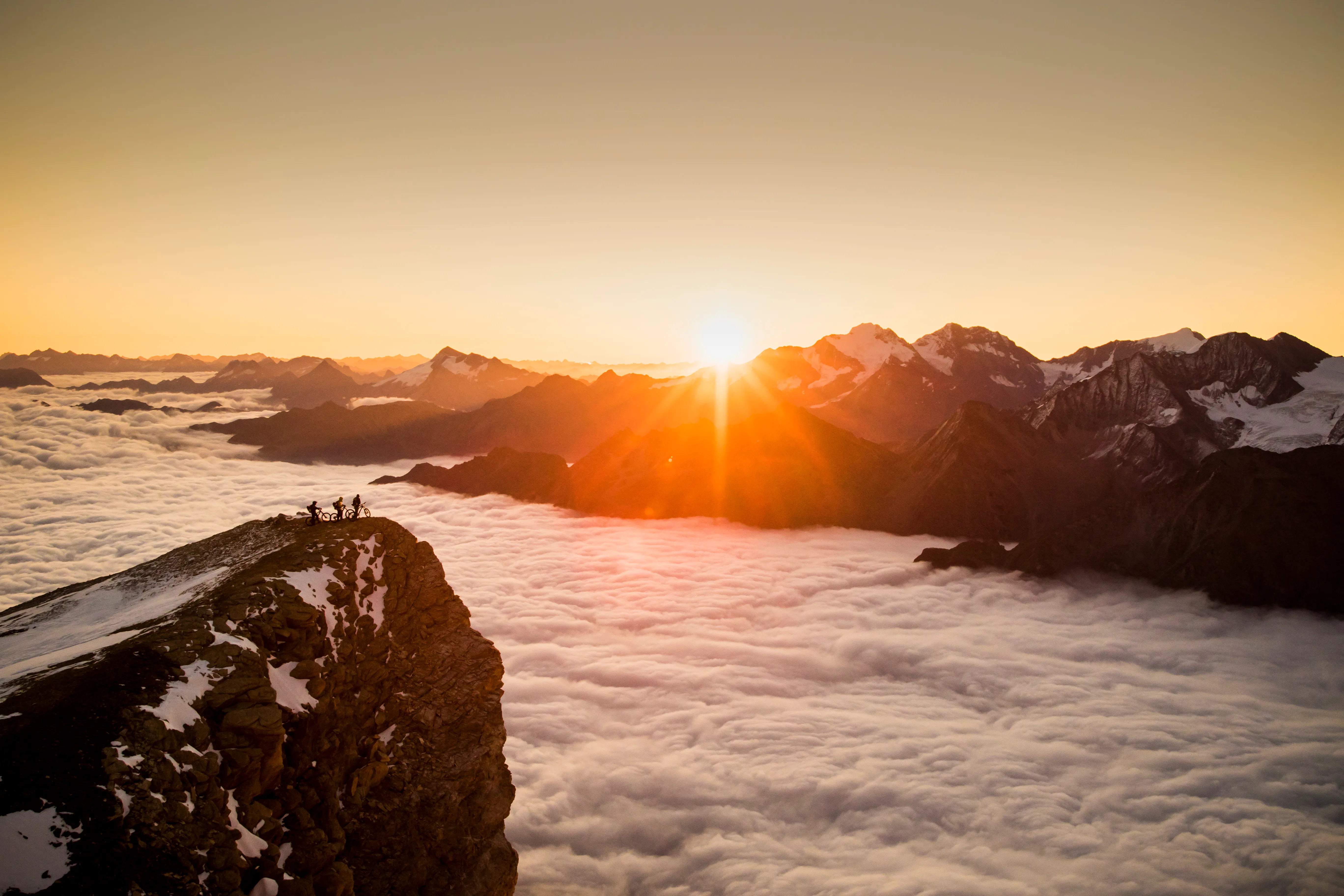 Ein felsiger Gipfel ragt über das Wolkenmeer im hochalpinen Wallis.