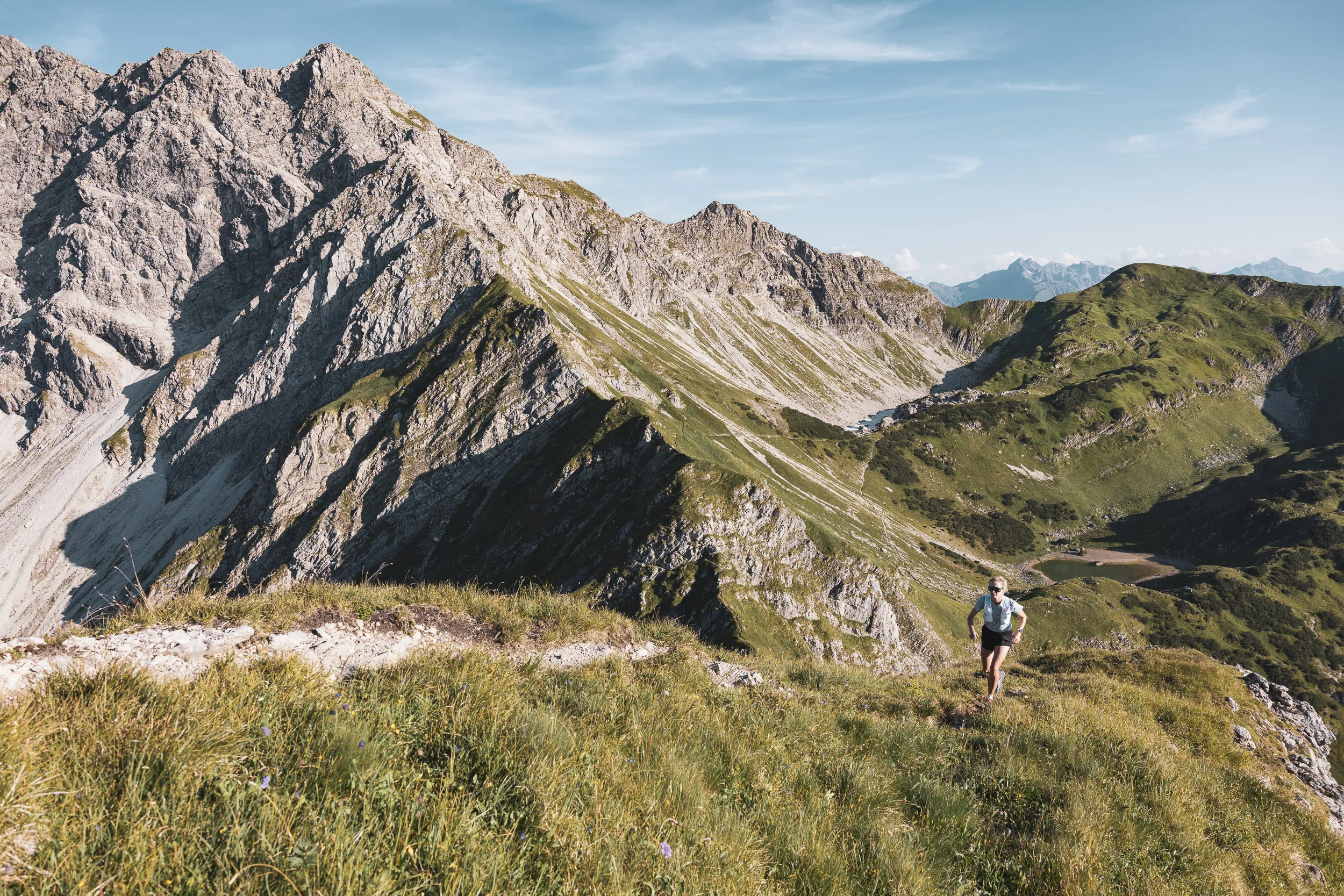 Kleine Trailrunnerin unter einem felsigen Gipfel in den Allgäuer Alpen