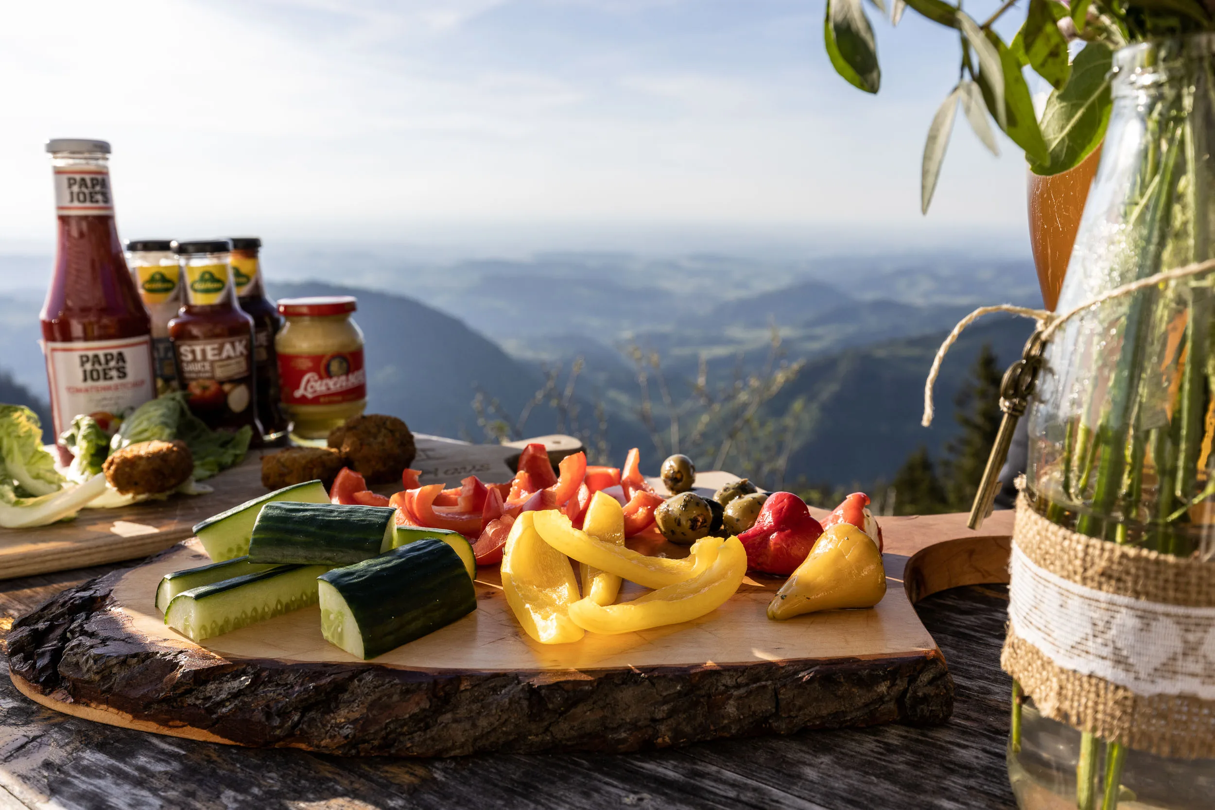 Brotzeit und Getränke auf einem Tisch mit Bergblick am Hochgrat.