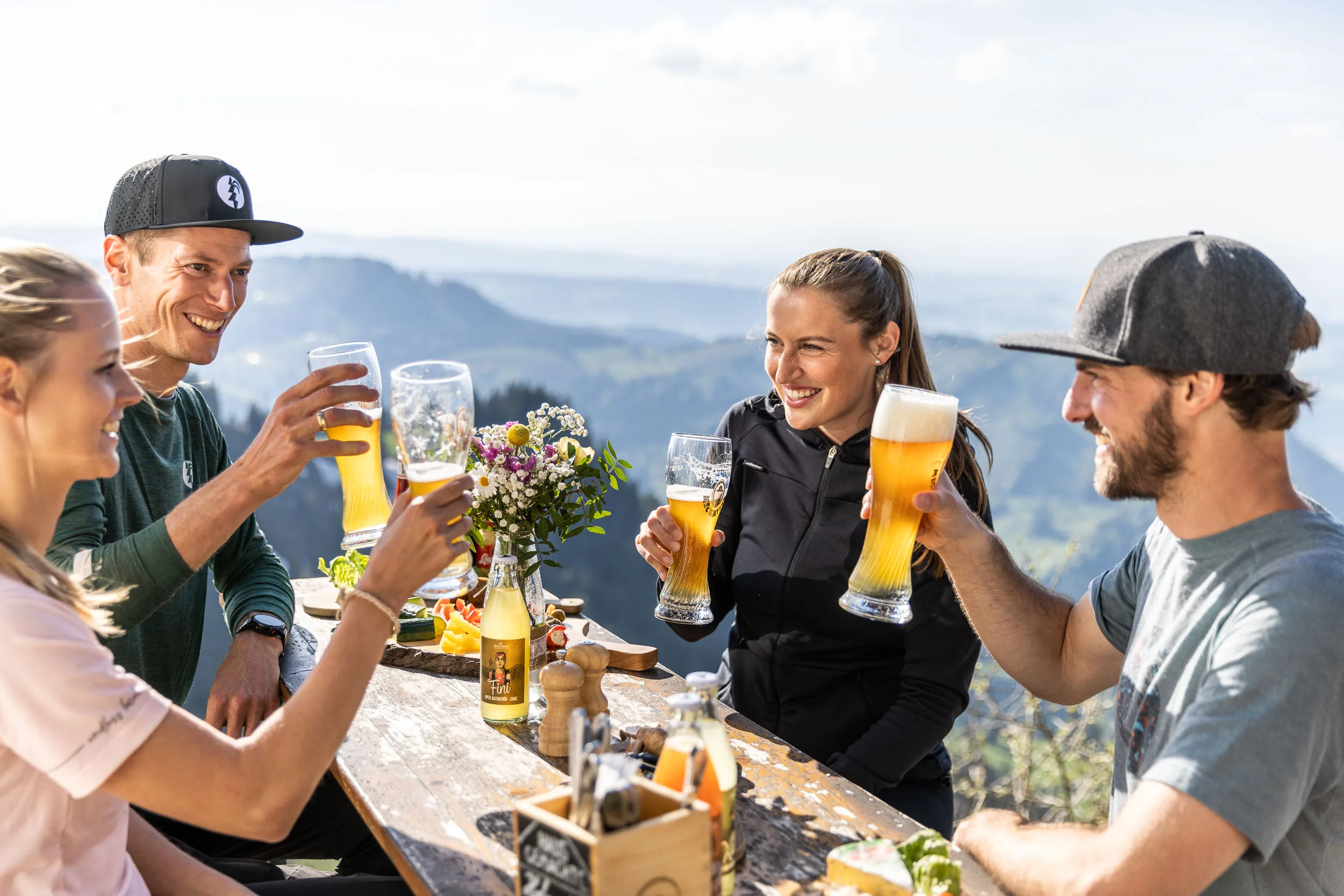 Brotzeit und Getränke auf einem Tisch mit Bergblick am Hochgrat.