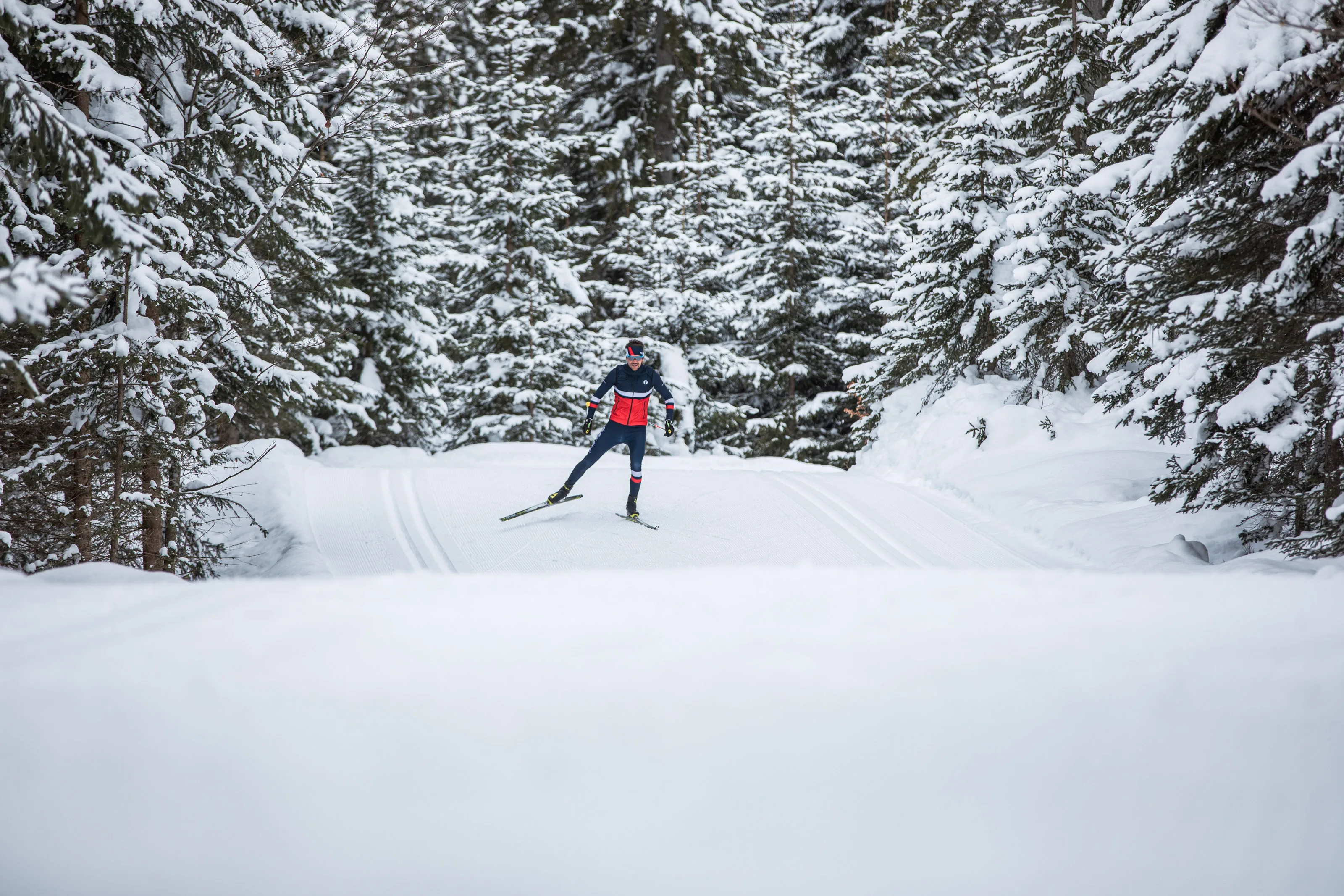 Michael Schnetzer im Skating-Schritt auf einer gewalzten Loipe im Winterwald.