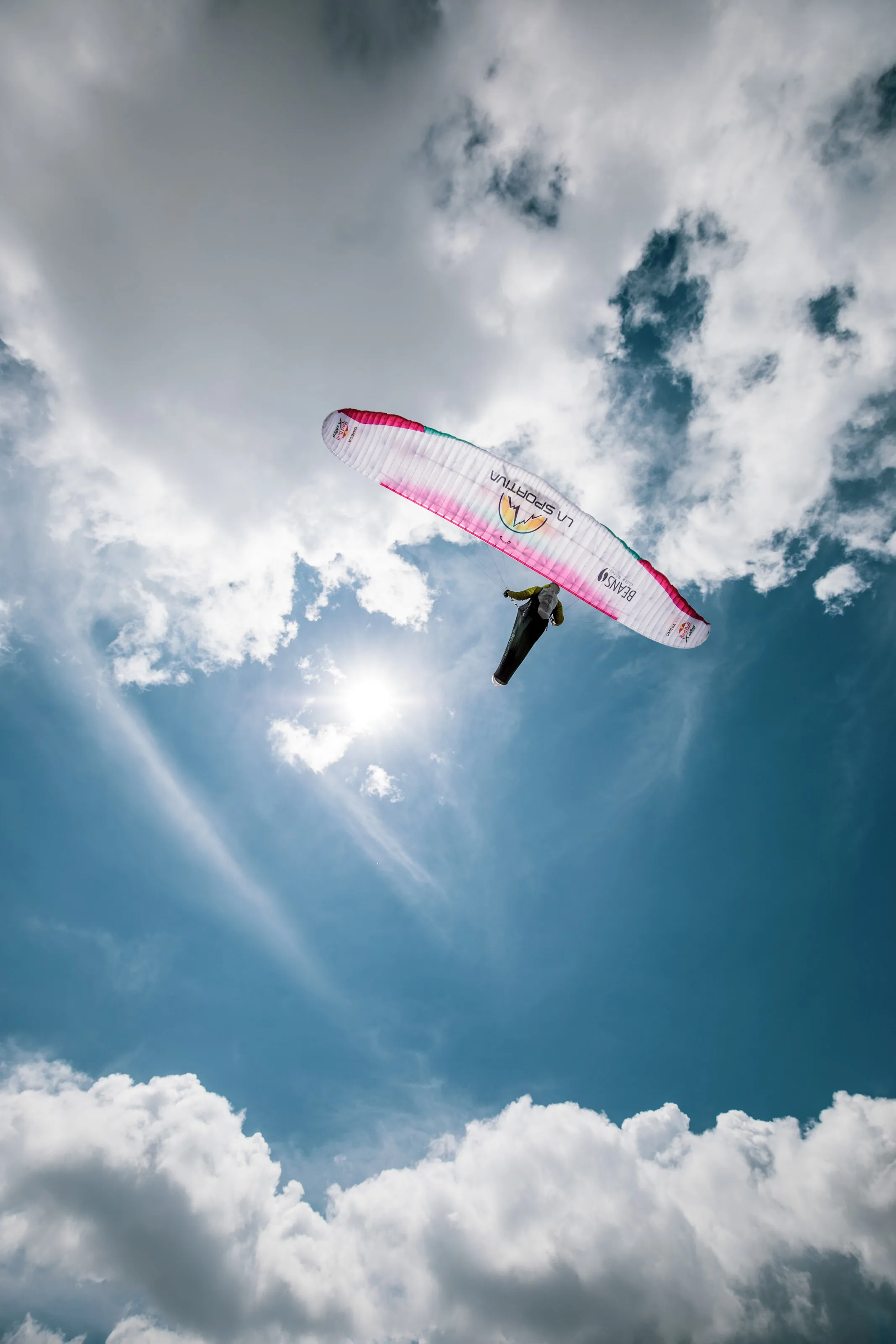 Der Gleitschirm von Michael Lacher steht vor der Sonne und einer hellen Wolkenlücke.