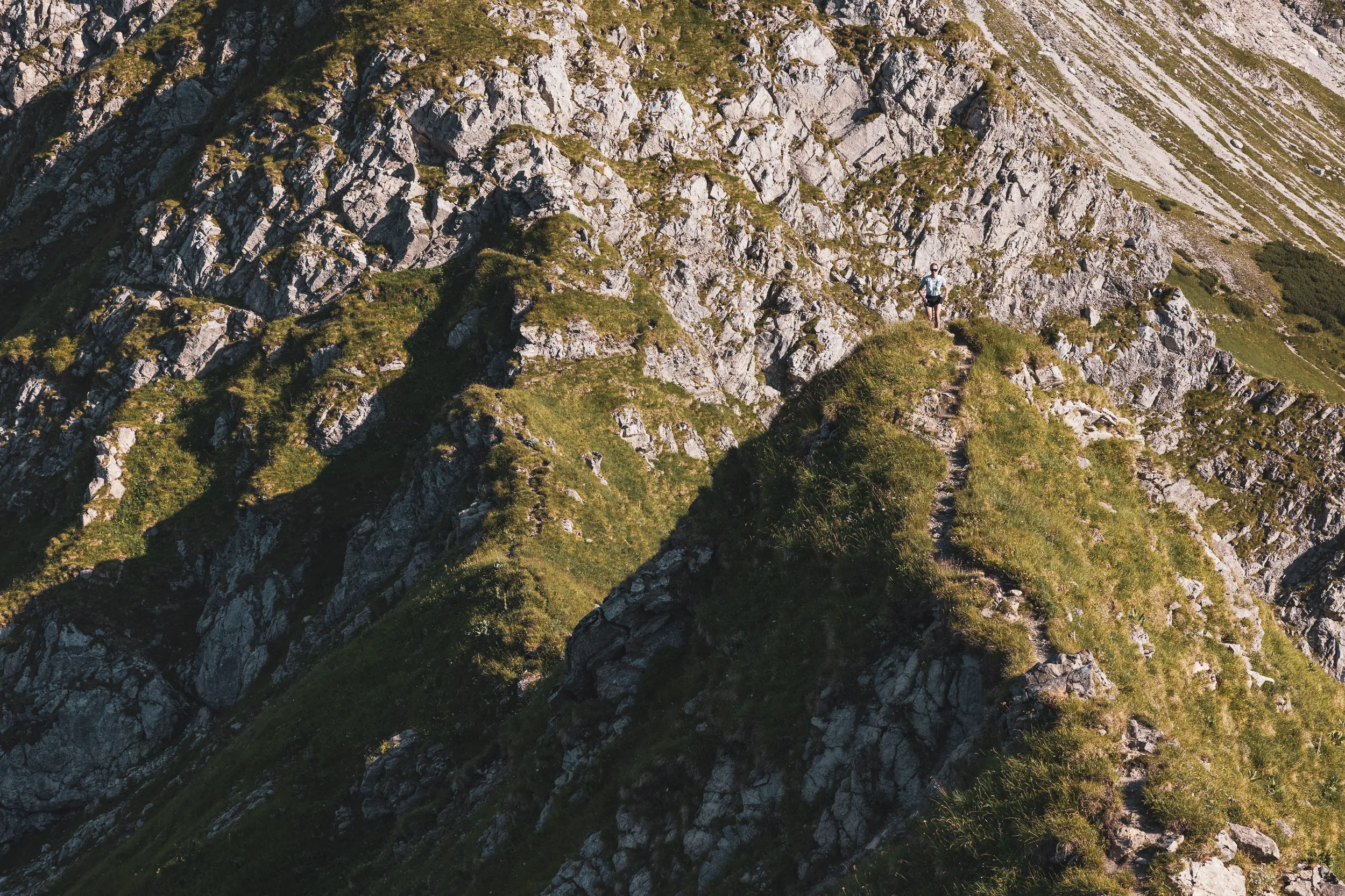 Felsiger Berggrat mit schmalem Pfad im warmen Abendlicht