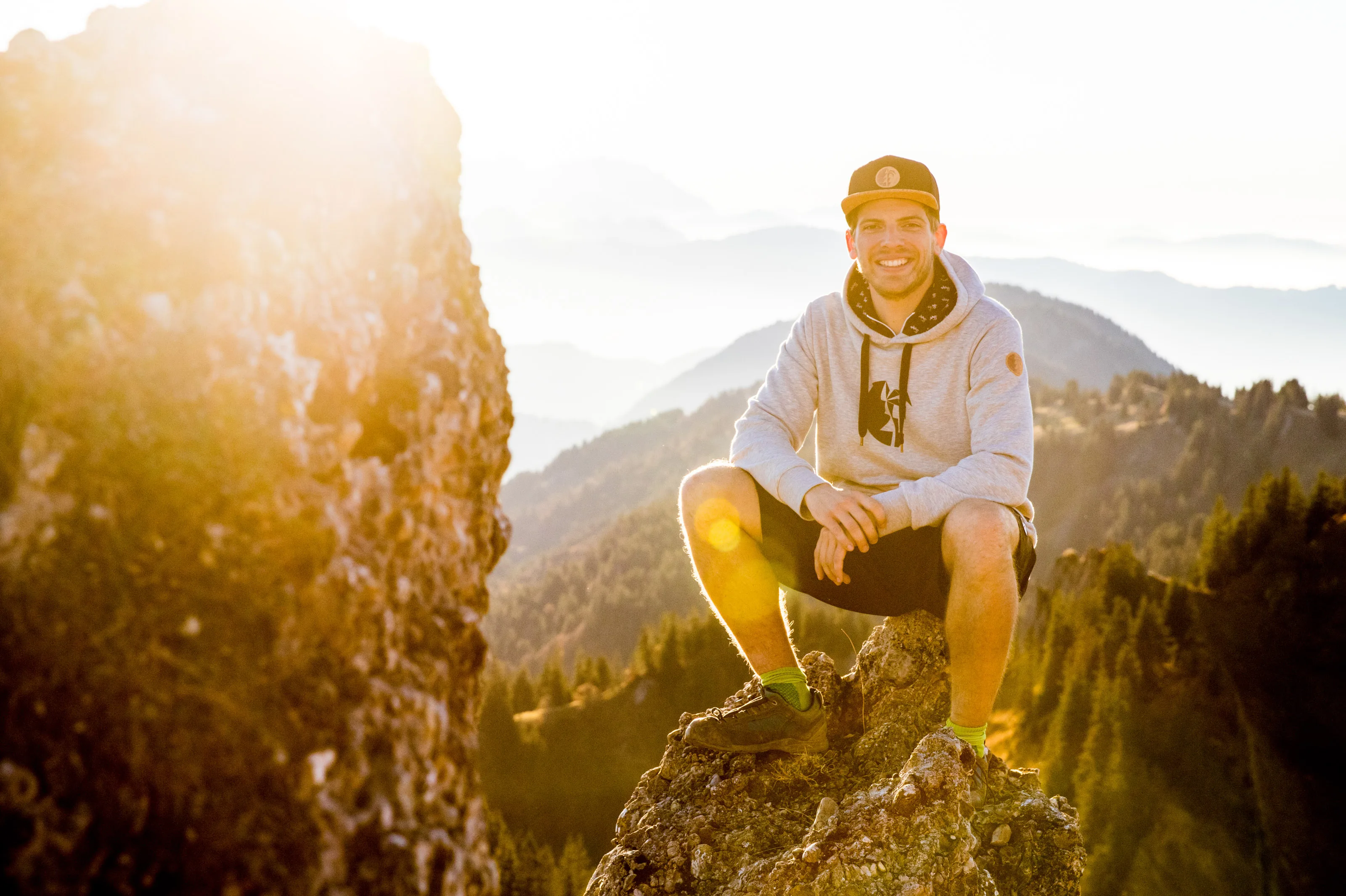 Florian Häusler sitzt auf einem Felsen im warmen Abendlicht.