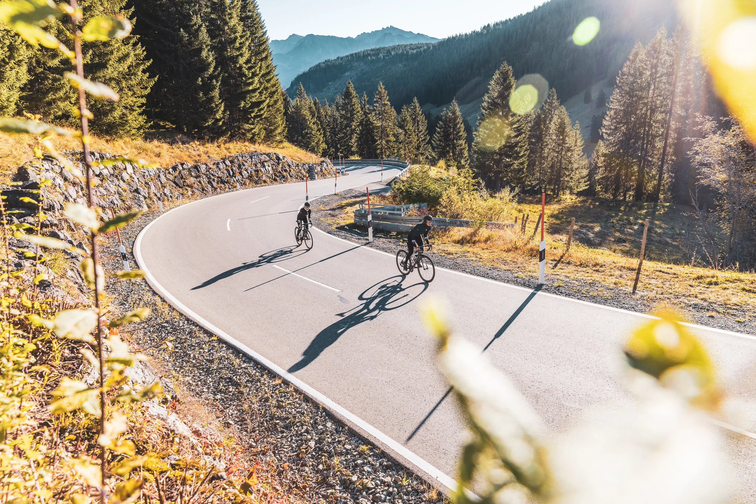 Luftaufnahme von zwei Rennradfahrerinnen in einer Passkurve