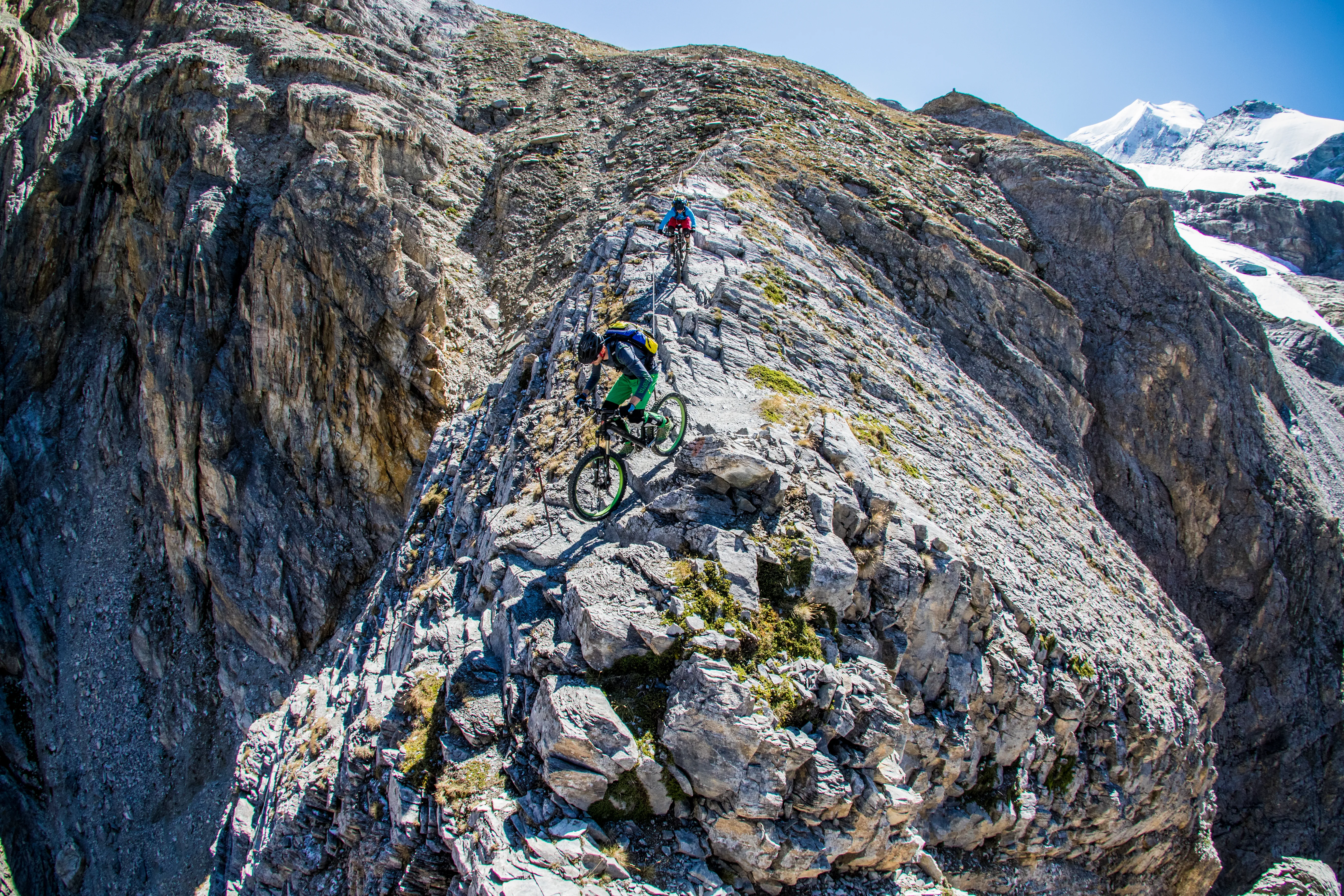 Robert Härle und Floran Bergmann fahren mit den Mountainbikes auf einem schmalen, felsigen Trail am Barrhorn.