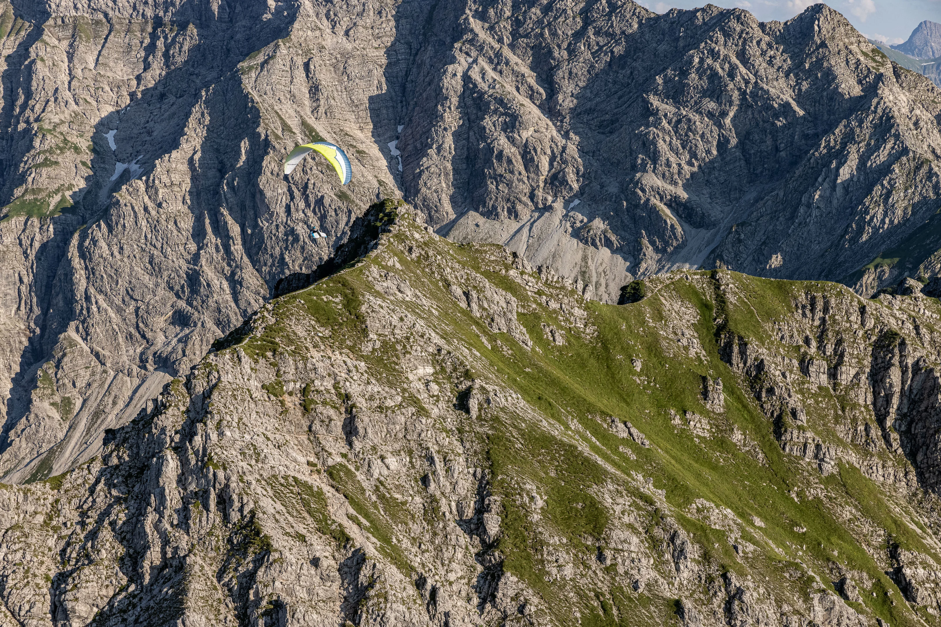 Michael Schnetzer mit seinem Gleitschirm fliegt vor dem Entschenkopf im Abendlicht