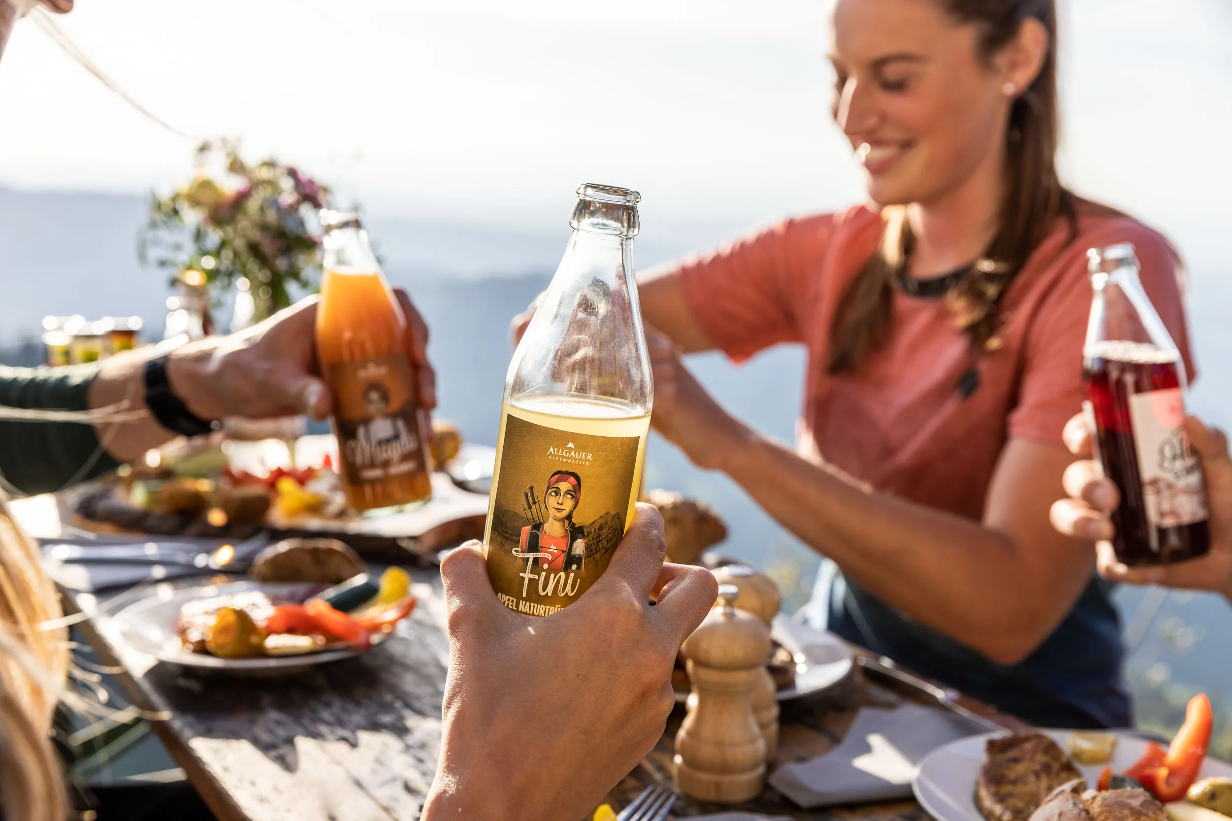 Brotzeit und Getränke auf einem Tisch mit Bergblick am Hochgrat.