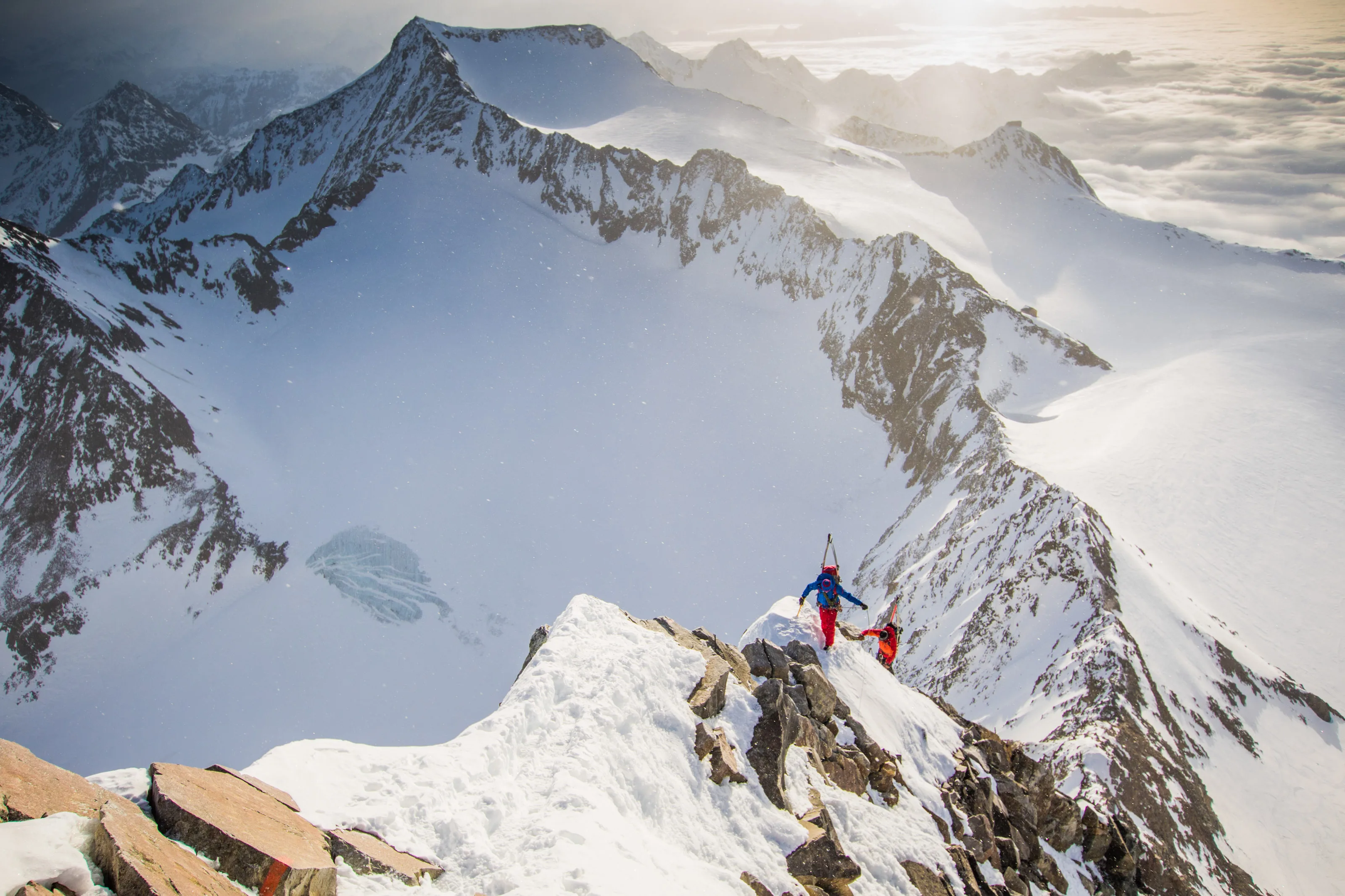 Florian Häusler und Tobias Baur stehen auf einem schmalen Schneegrat vor einem Gipfelpanorama