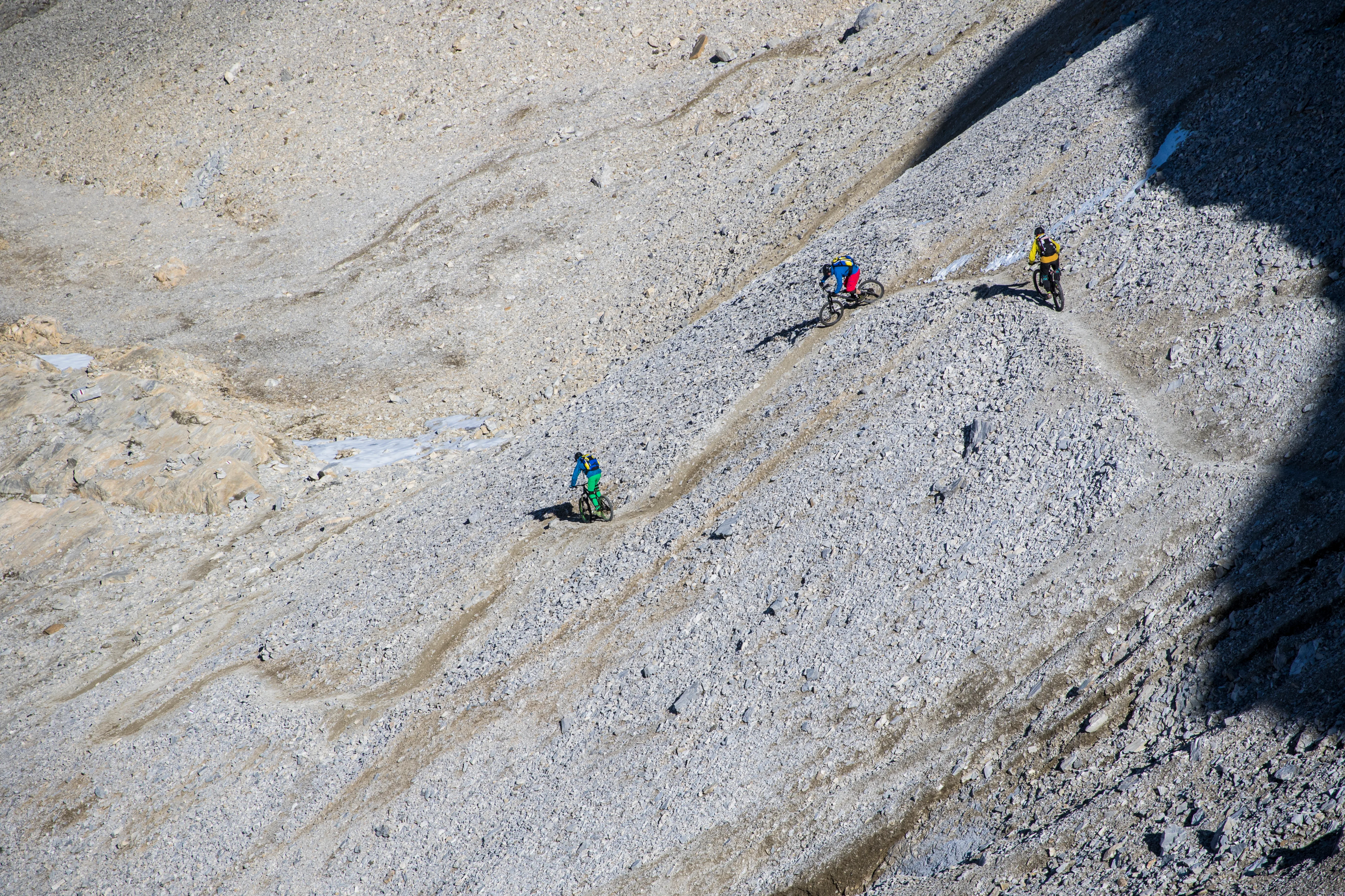 Robert Härle, Florian Bergmann und Florian Häusler fahren durch ein hochalpines Geröllfeld am Barrhorn.