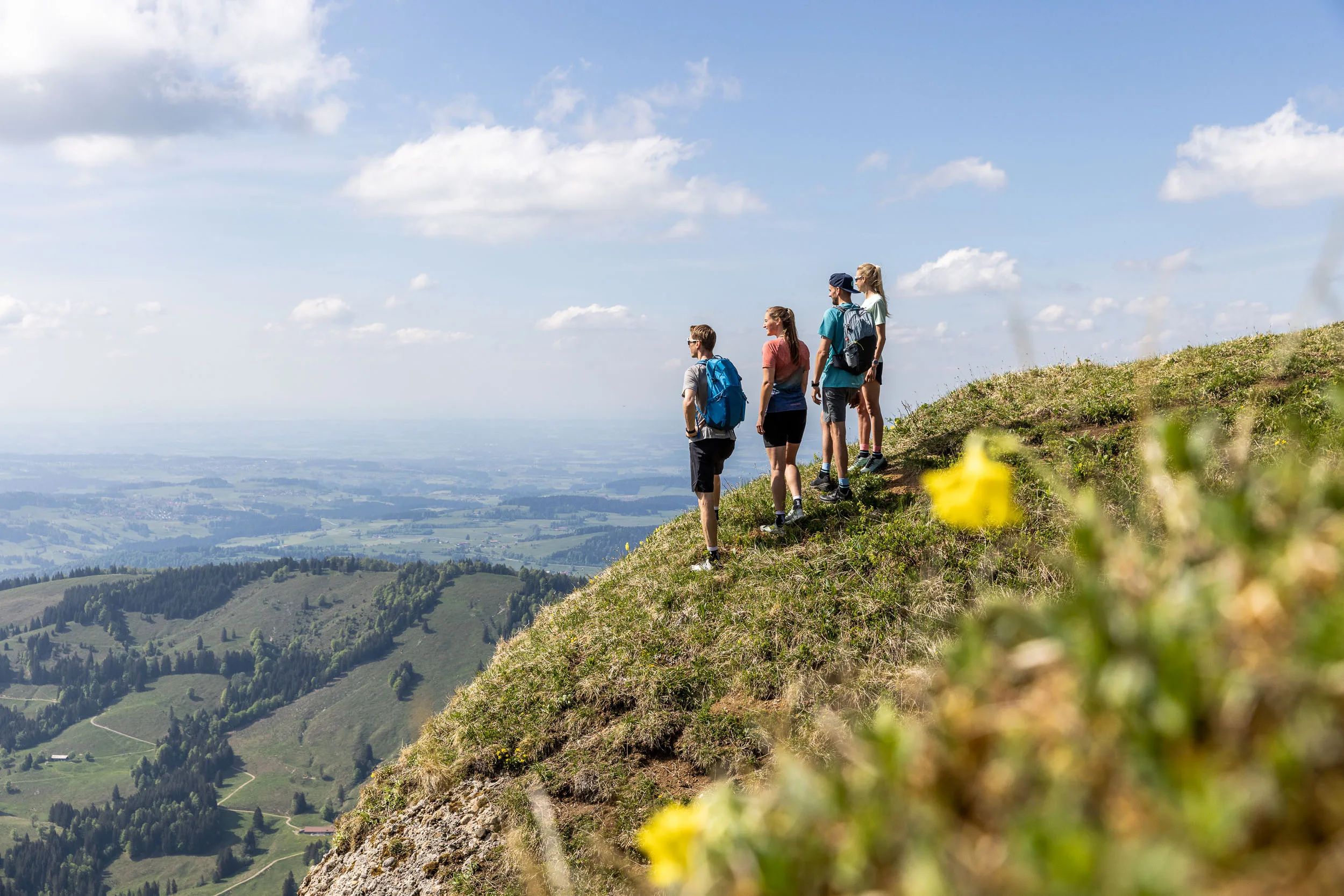 Wandernde auf einem Bergweg am Hochgrat mit Blick über das Allgäu.