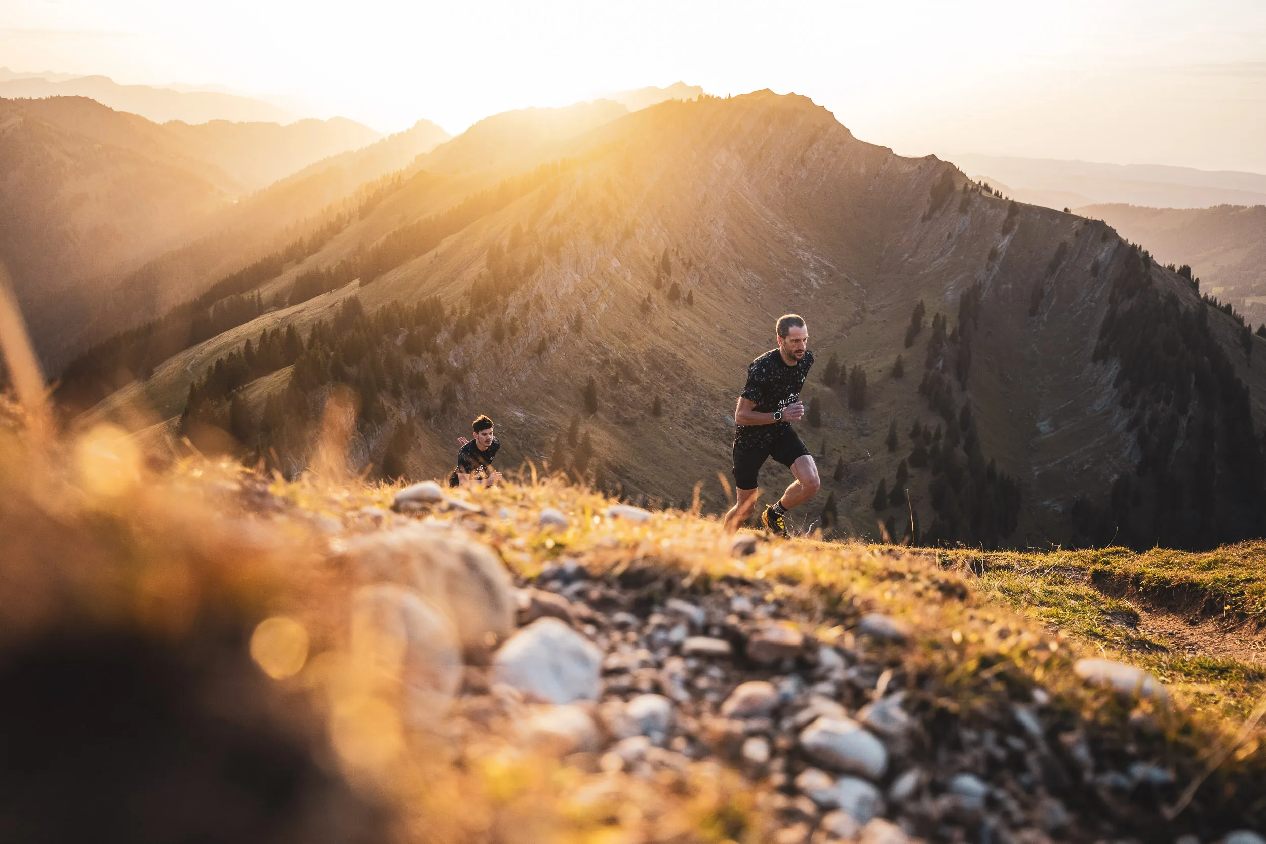 Trailrunner laufen hinter unscharfen Mineralwasserflaschen im Abendlicht