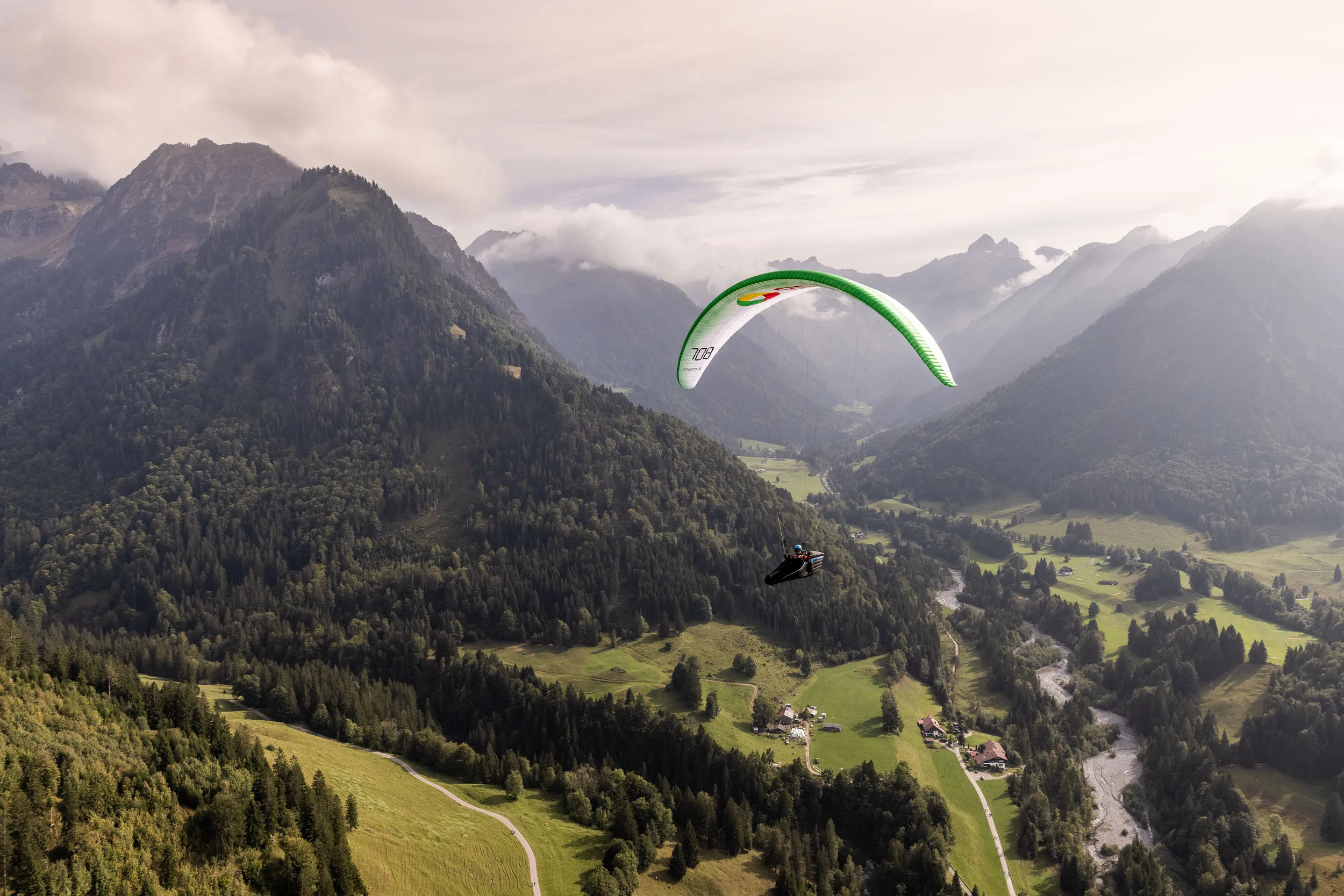 Klaudia Bulgakow fliegt mit ihrem Gleitschirm über einem Bergtal bei Oberstdorf.