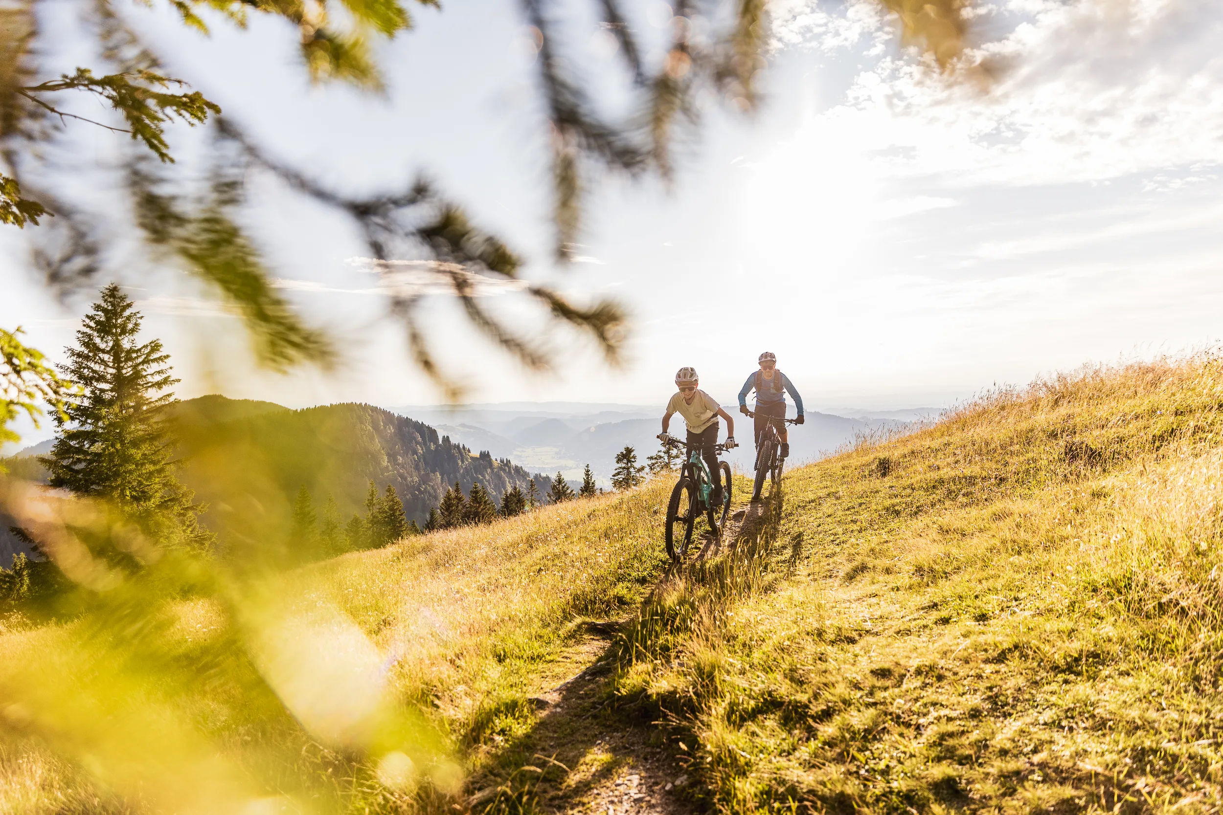 Florian Häusler und Kilian Morell fahren mit ihren Bikes im warmen Abendlicht