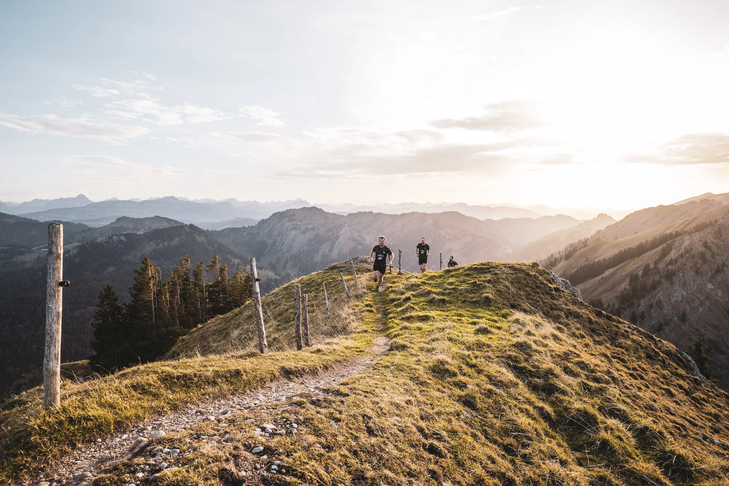 Laufteam auf schmalem Bergpfad in der Nagelfluhkette bei tief stehender Sonne