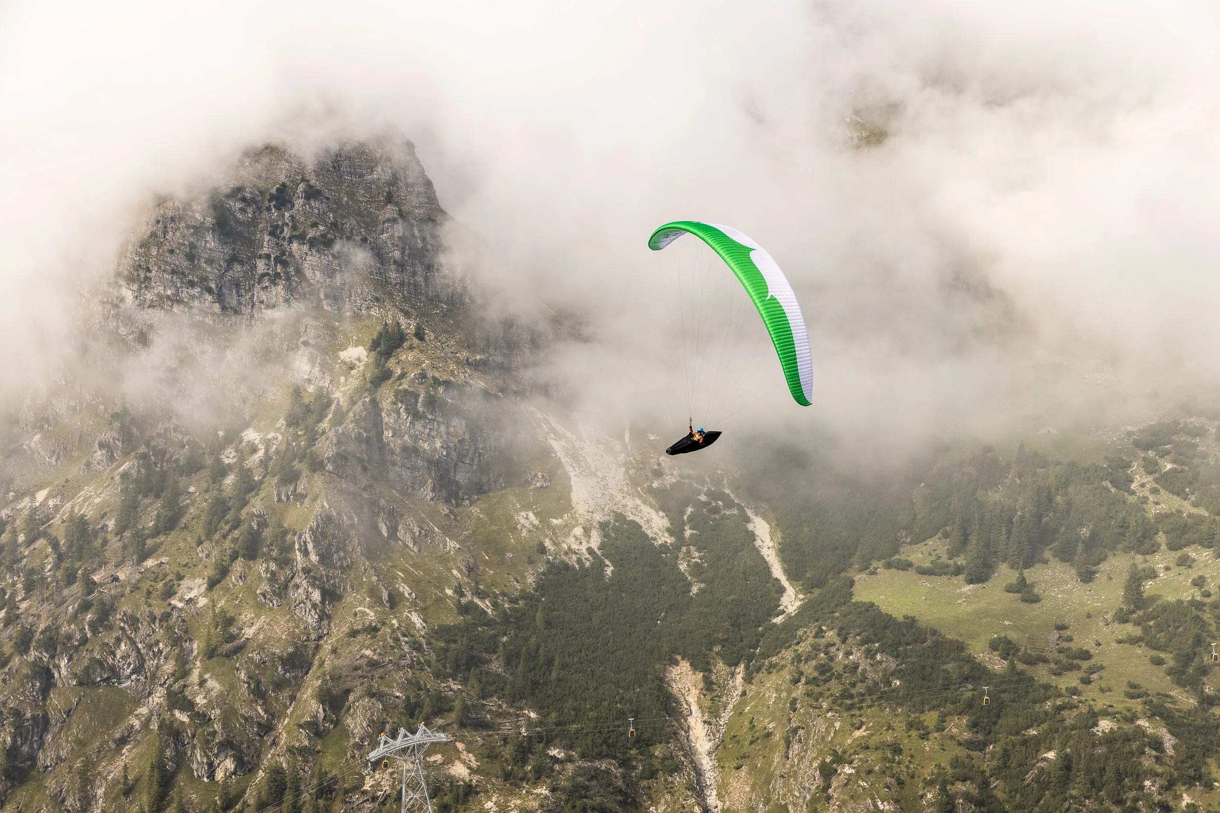 Klaudia Bulgakow fliegt mit ihrem Gleitschirm vor einem schroffen Grat am Nebelhorn.