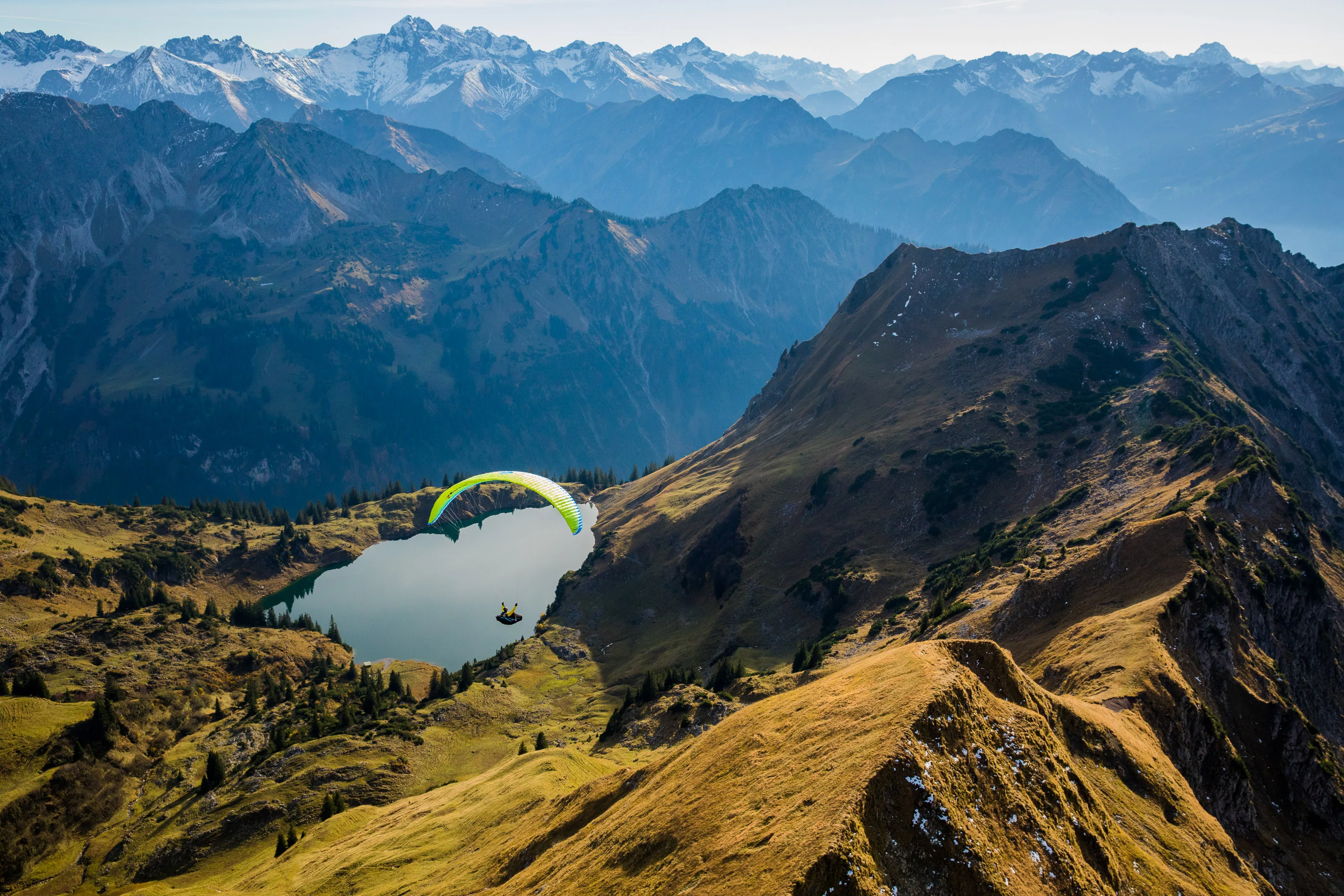 Michael Gebert fliegt hoch über dem türkisfarbenen Seealpsee, eingerahmt von Bergen im herbstlichen Allgäu