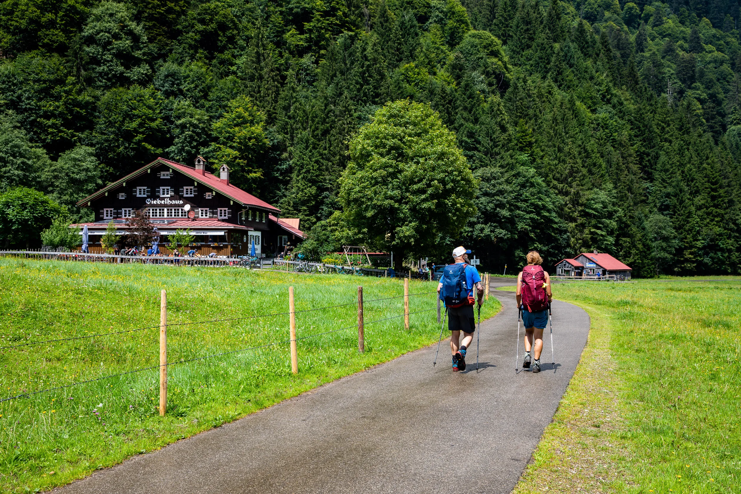 Caroline Nantke und Harald Dreyer gehen mit Rucksäcken auf einem Weg zum Giebelhaus