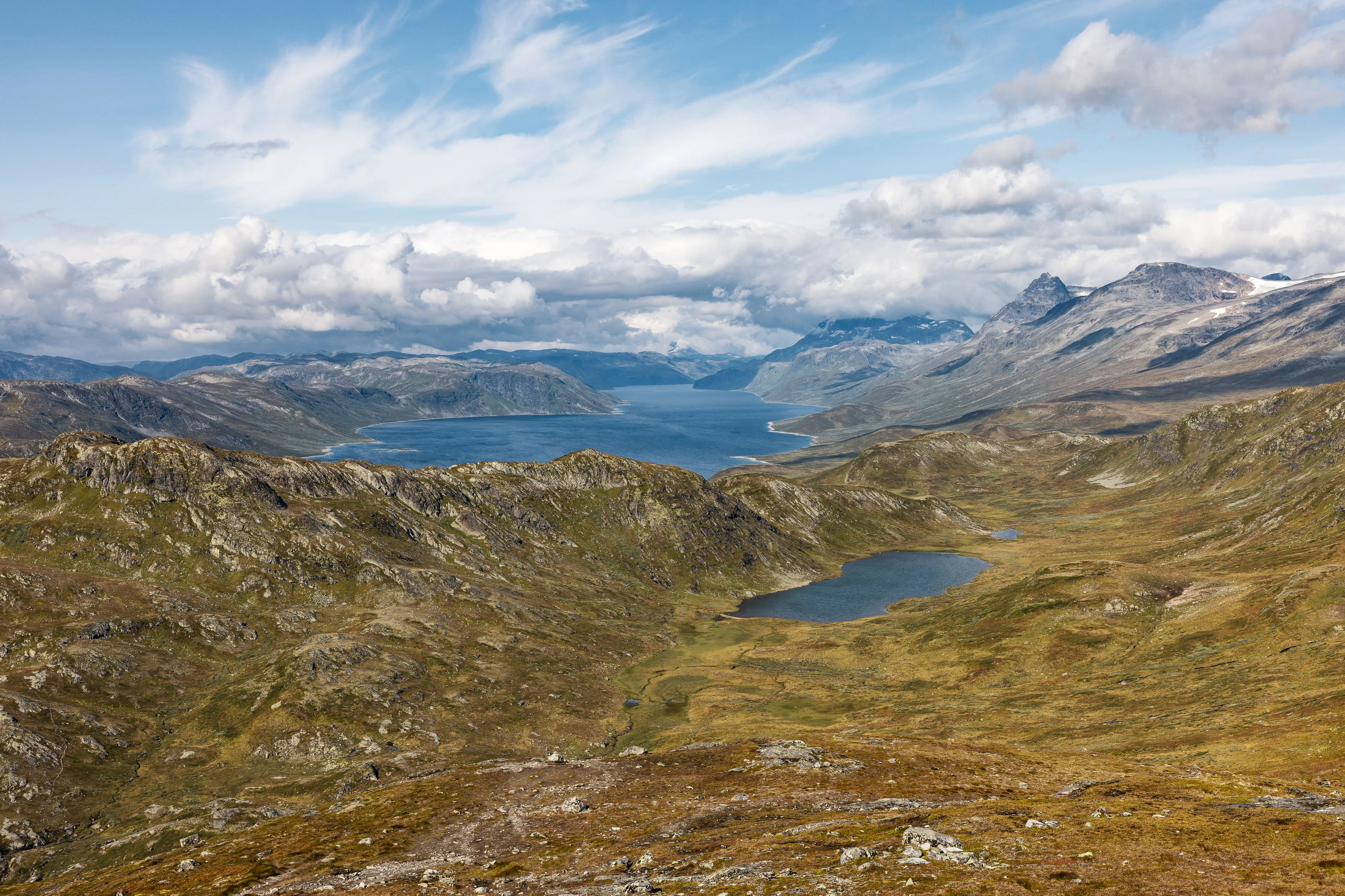 Weite norwegische Hochlandschaft mit mehreren Seen und fernen Bergketten