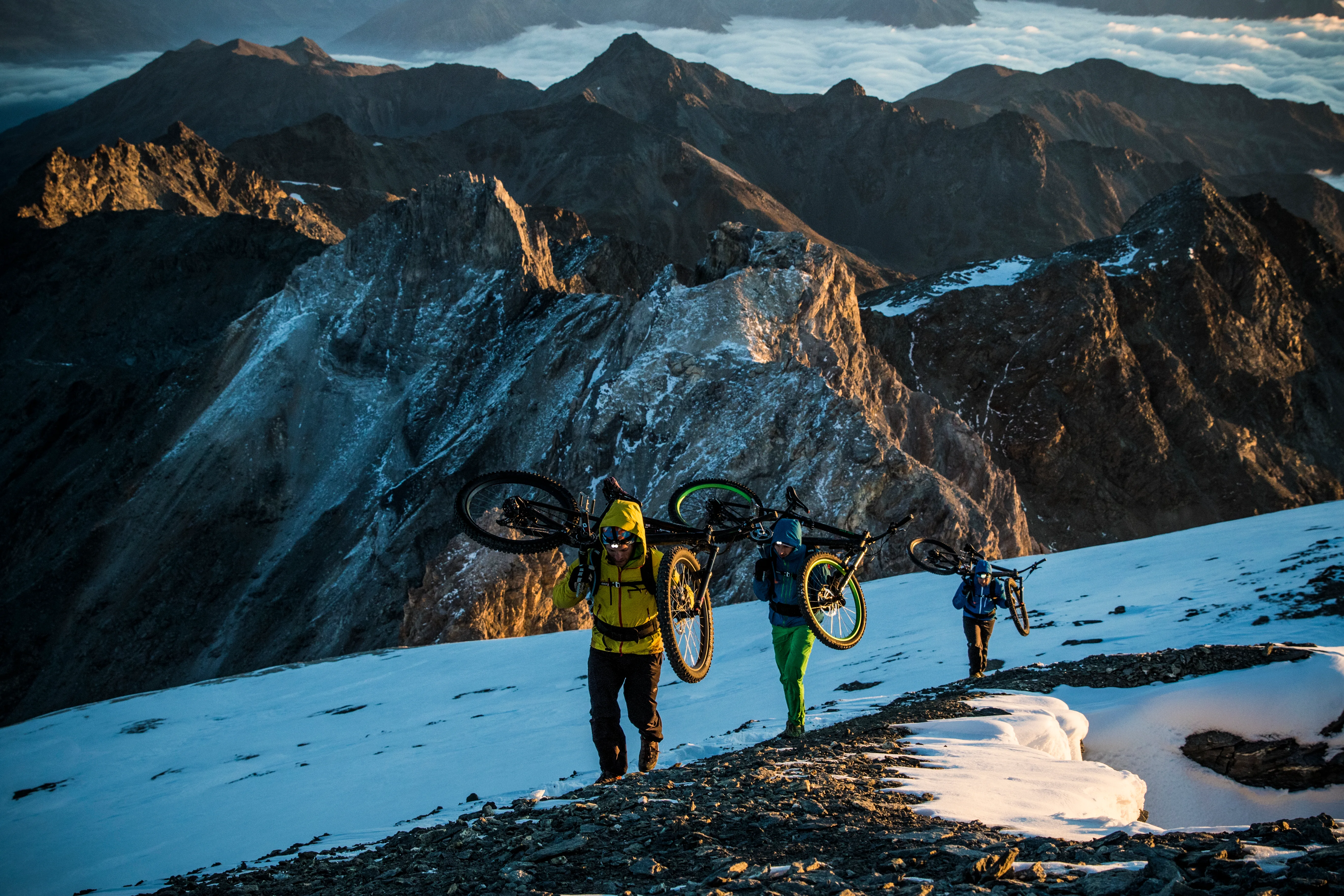 Robert Härle, Florian Bergmann und Florian Häusler sind mit ihren Mountainbikes im Abendlicht unterwegs.