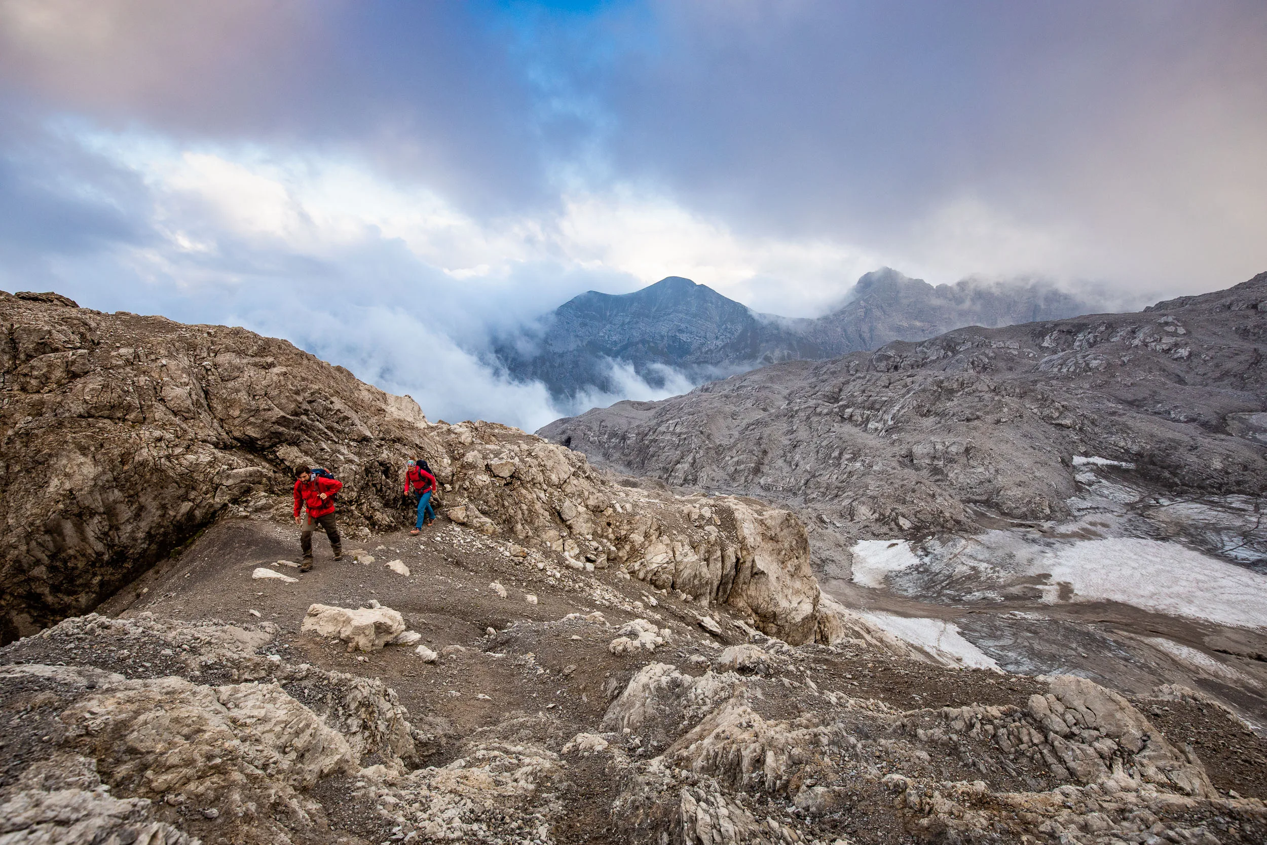 Raphaela Haug und Tom Besser steigen durch helles Kalkgestein oberhalb der Wolken auf