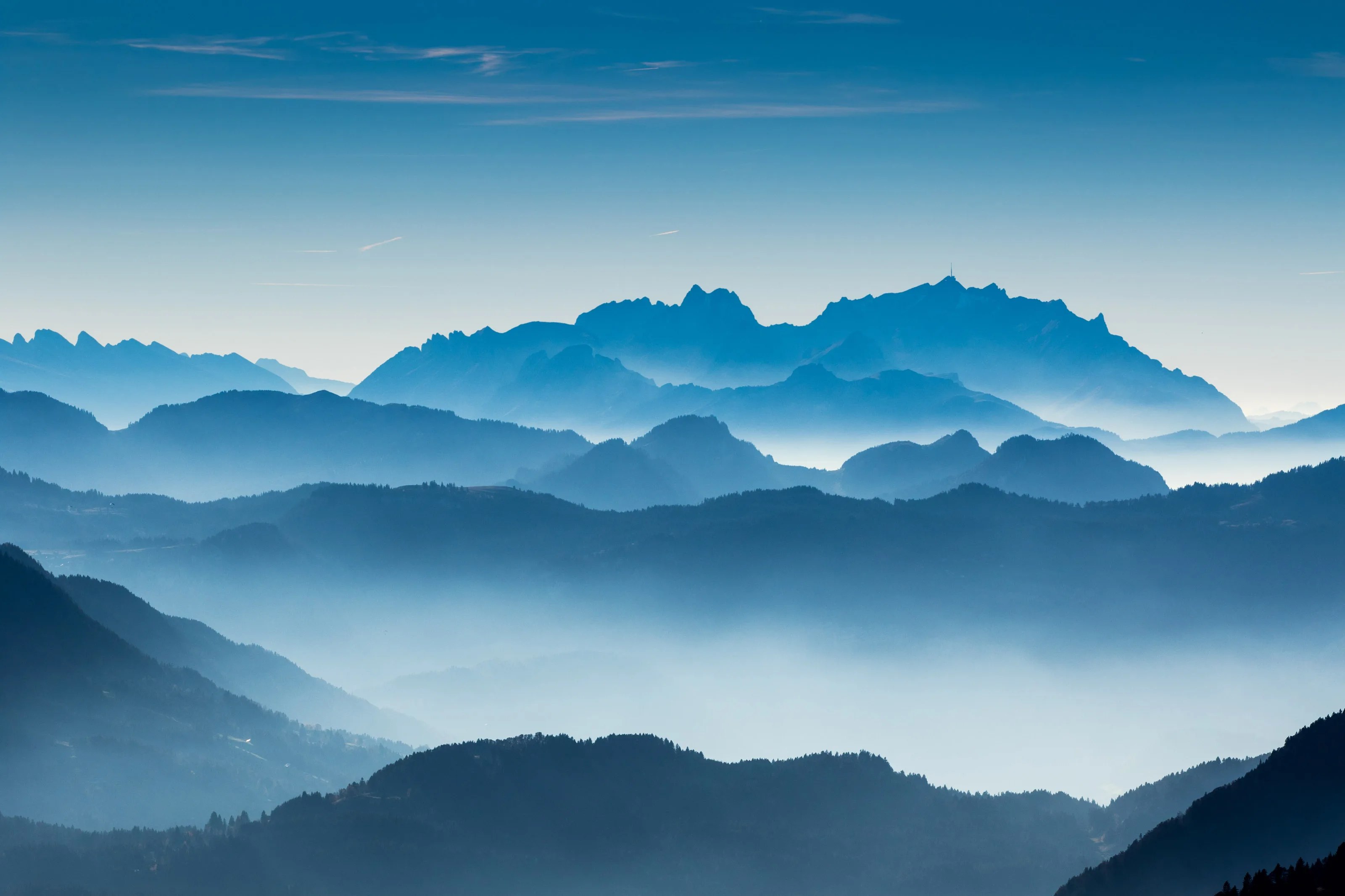 Bergketten und bewaldete Hügel im Dunst über dem Allgäu.