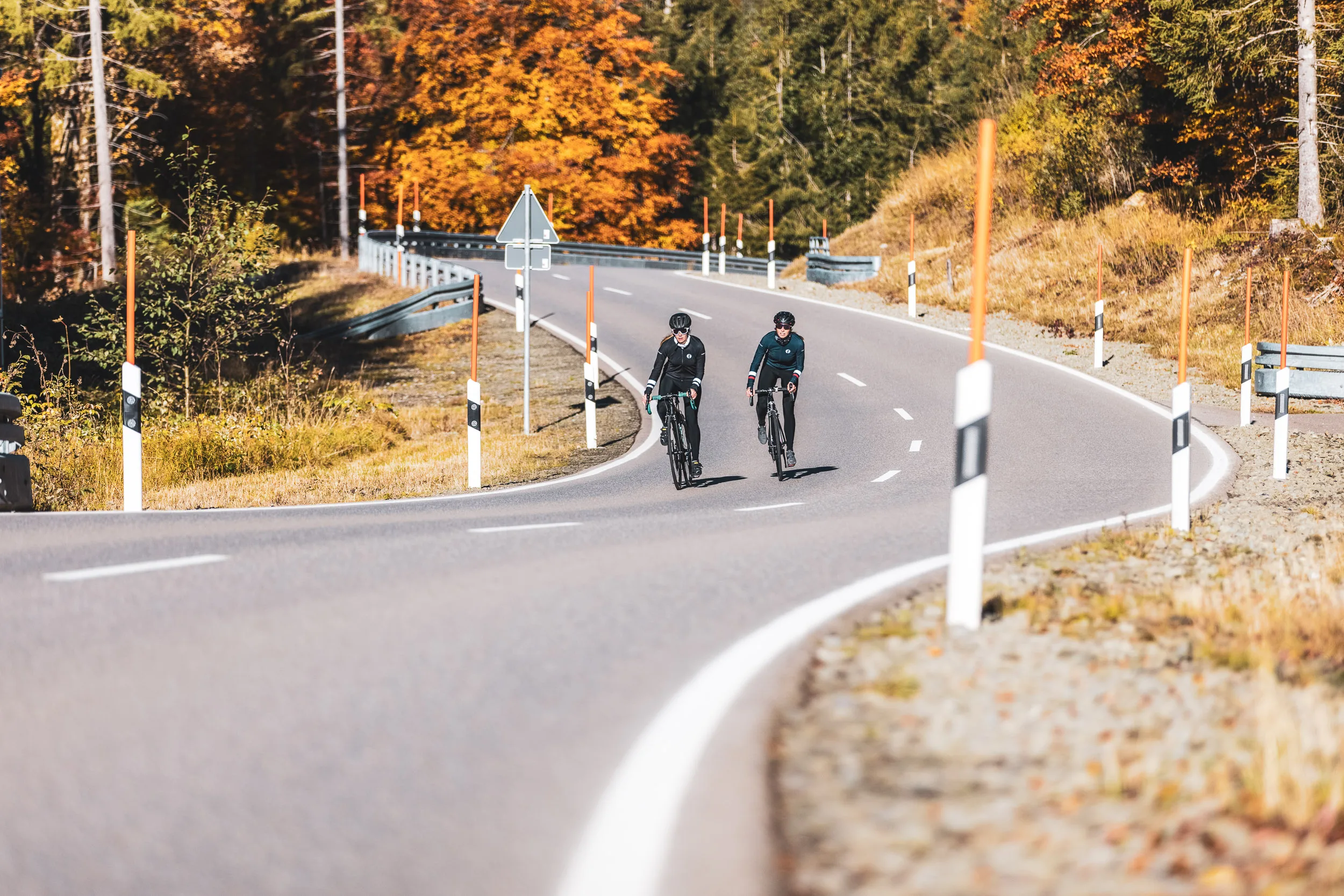 Zwei Rennradfahrerinnen folgen der geschwungenen Straße am Riedbergpass