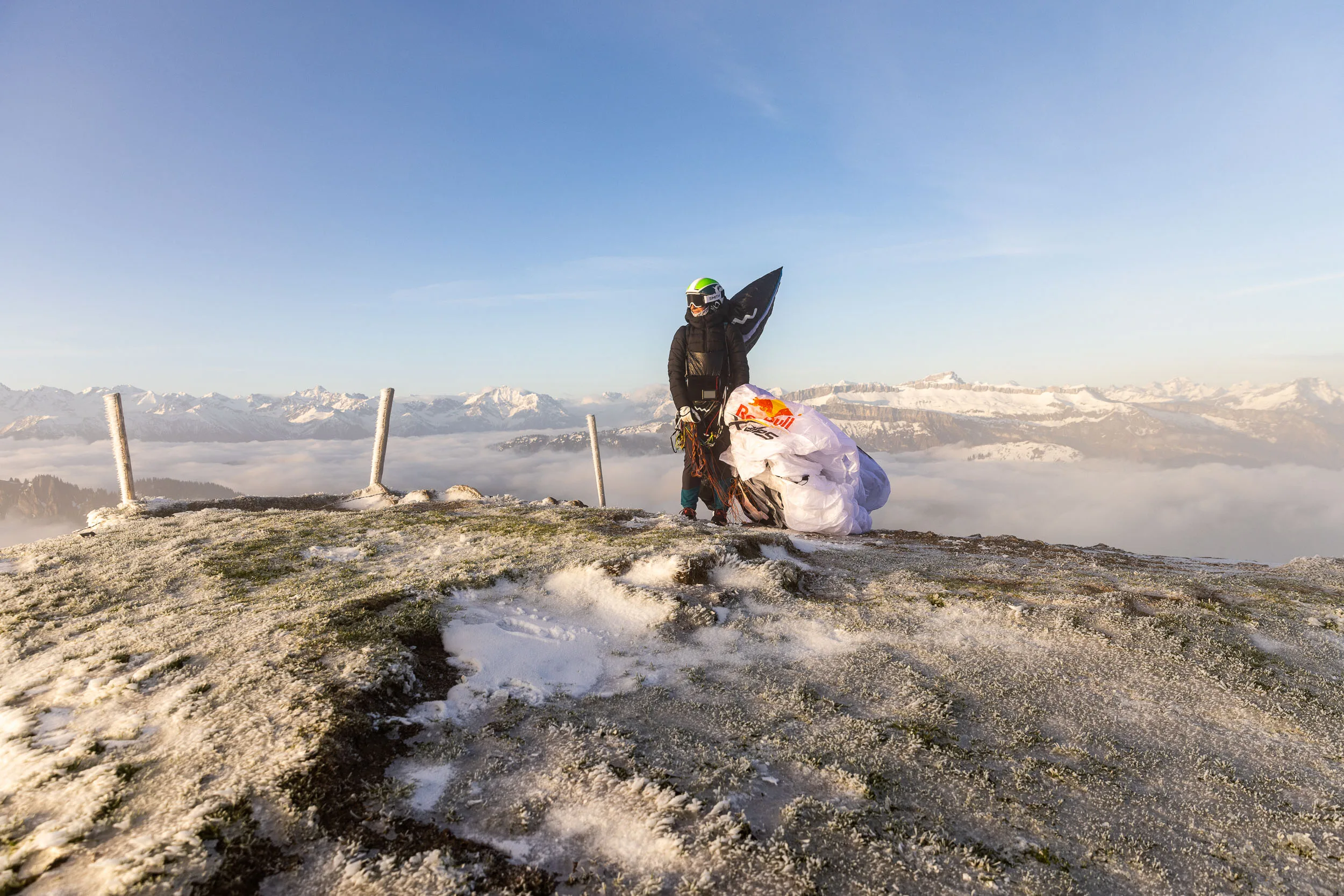 Eli Egger bereitet ihren Gleitschirm auf einem verschneiten Gipfel im Allgaeu vor.