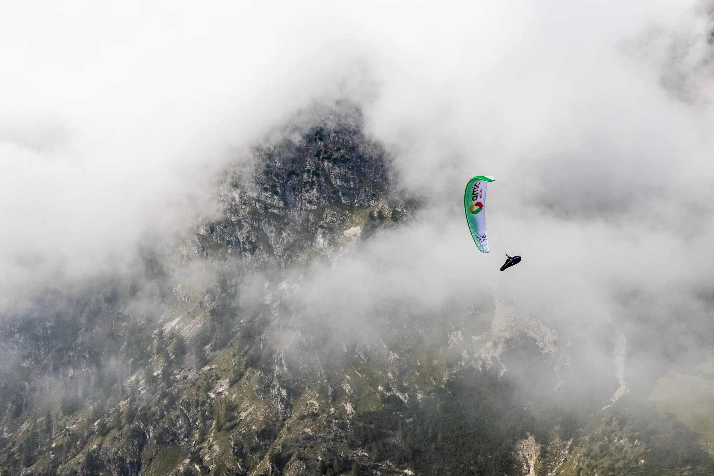 Klaudia Bulgakow fliegt mit ihrem Gleitschirm vor einer Felswand im Nebel am Nebelhorn.