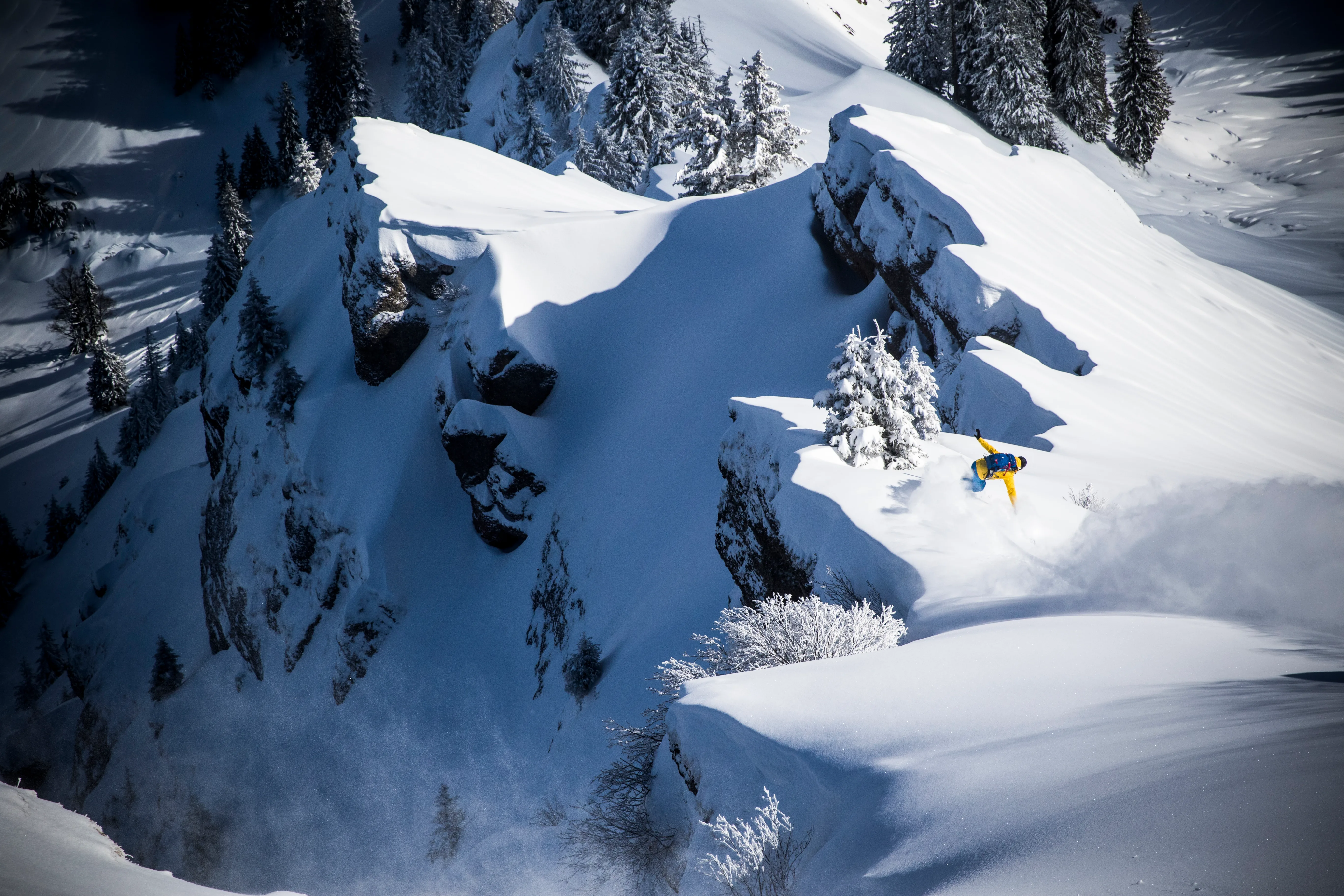 Ben Epp fährt mit dem Snowboard über frisch verschneite Felsstufen der Nagelfluhkette.