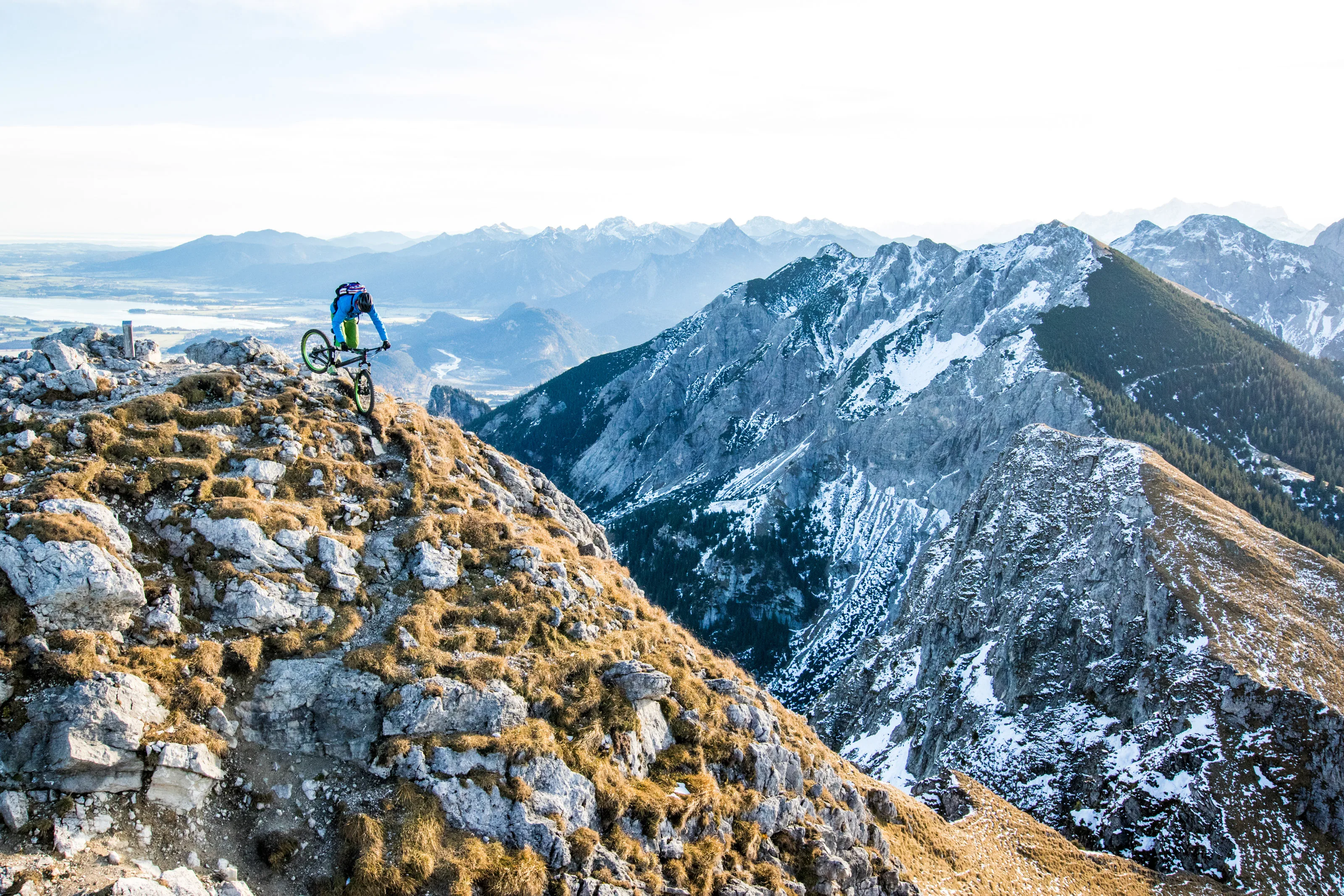Robert Härle mit Mountainbike auf felsigem Gelände. Blick Richtung Füssen