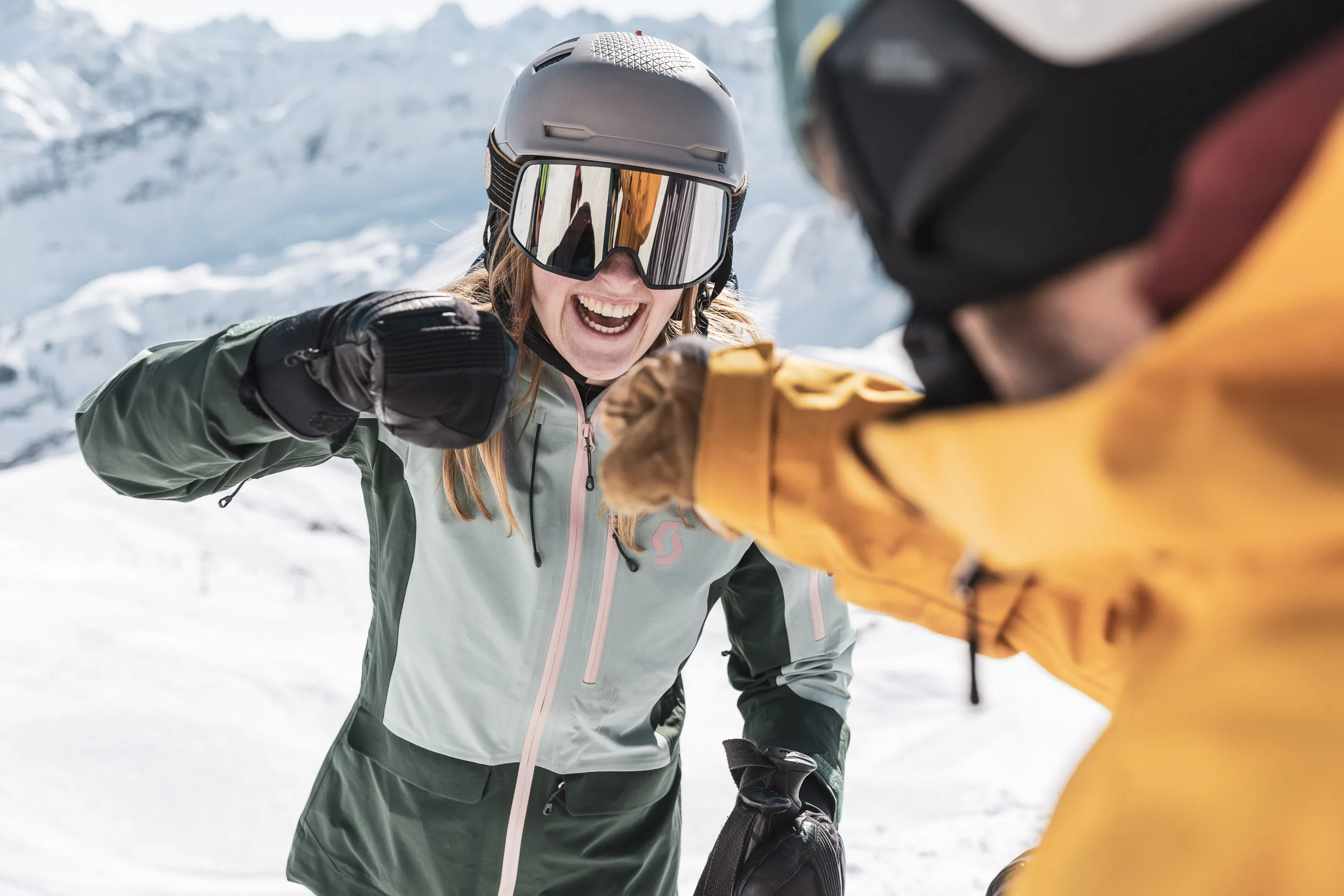 Skifahrerin und Skilehrer begrüßen sich mit den Fäusten auf der Piste