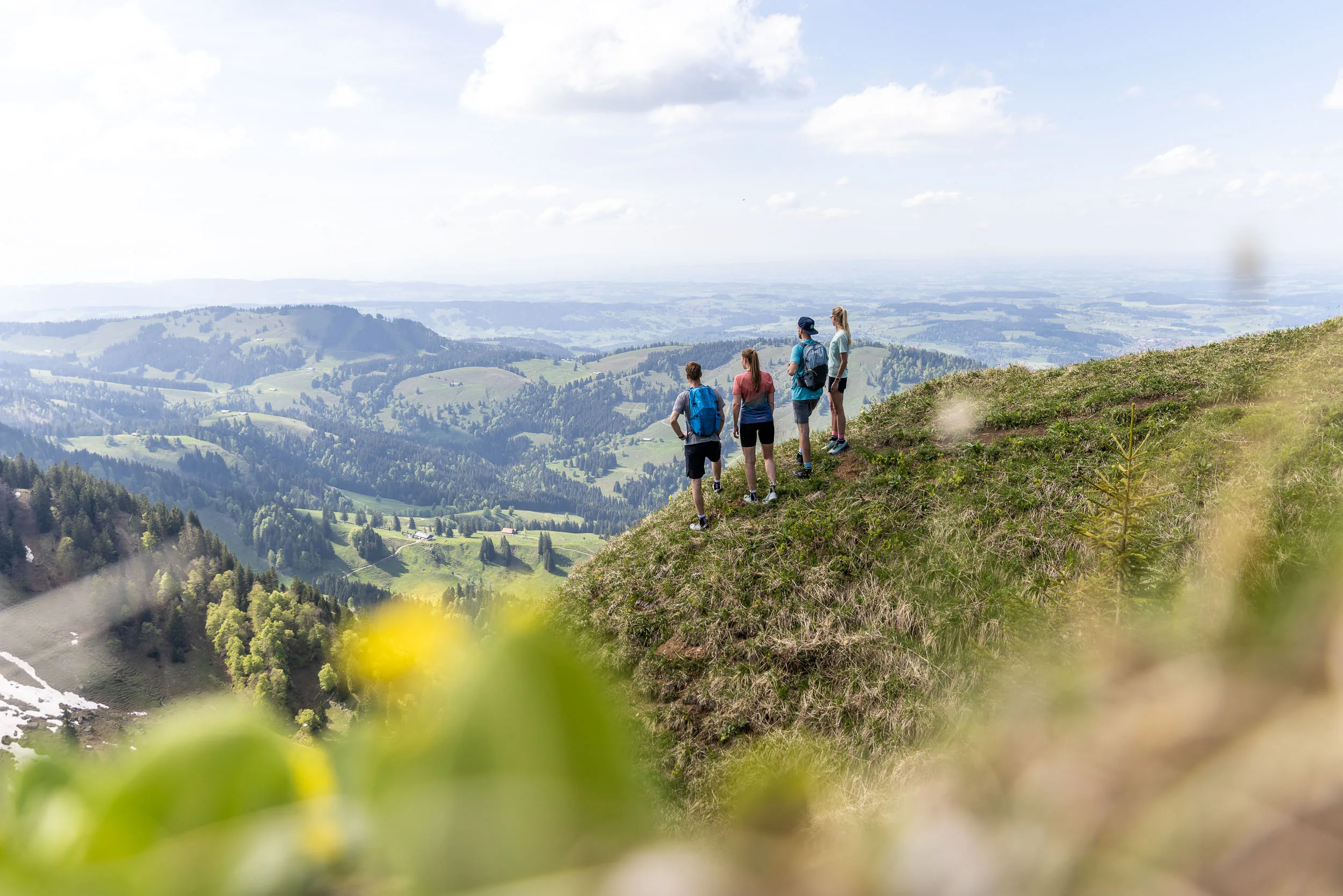 Wandernde auf einem Bergweg am Hochgrat mit Blick über das Allgäu.