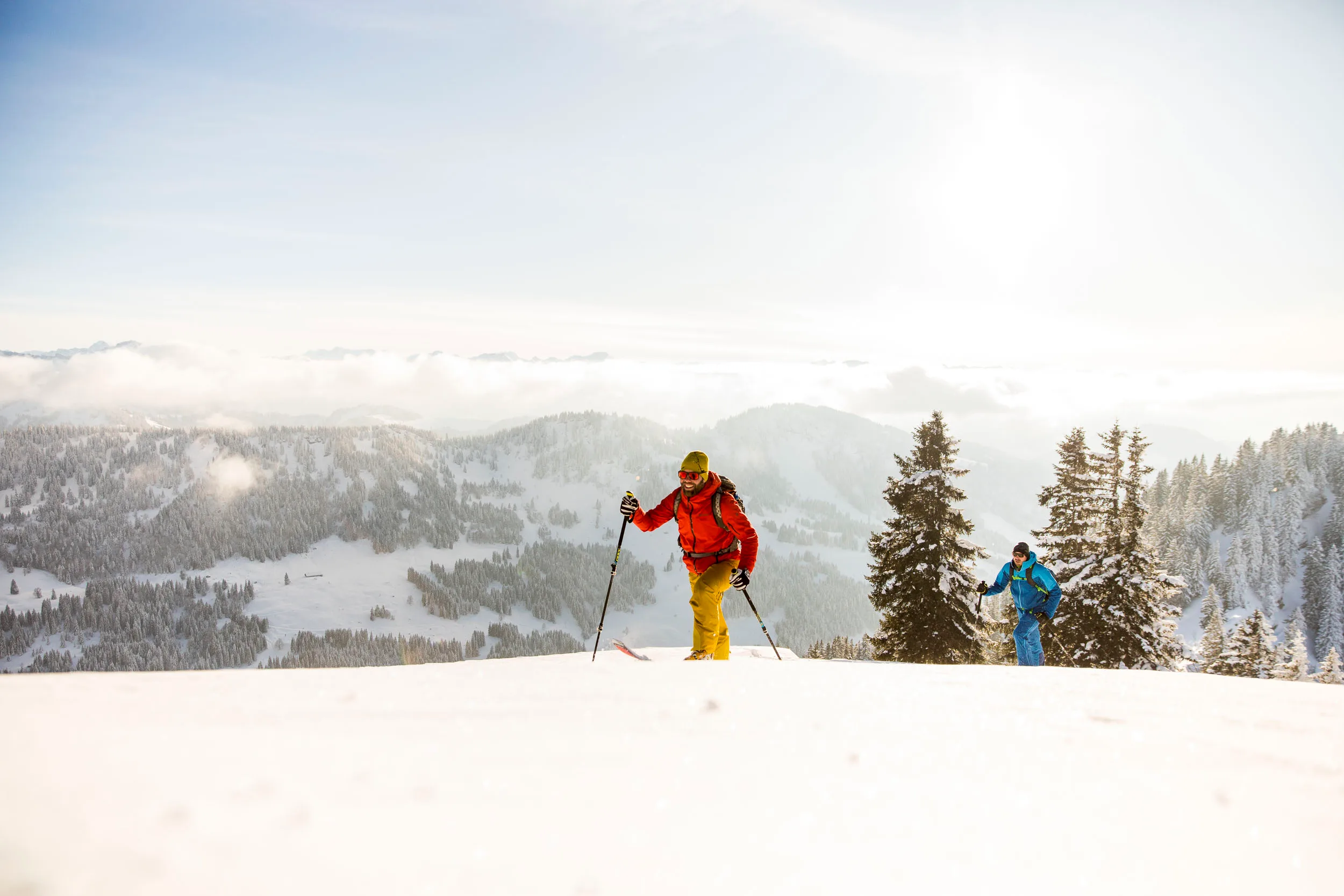 Skitourengeher steigen durch eine helle Schneefläche am Hochgrat auf.